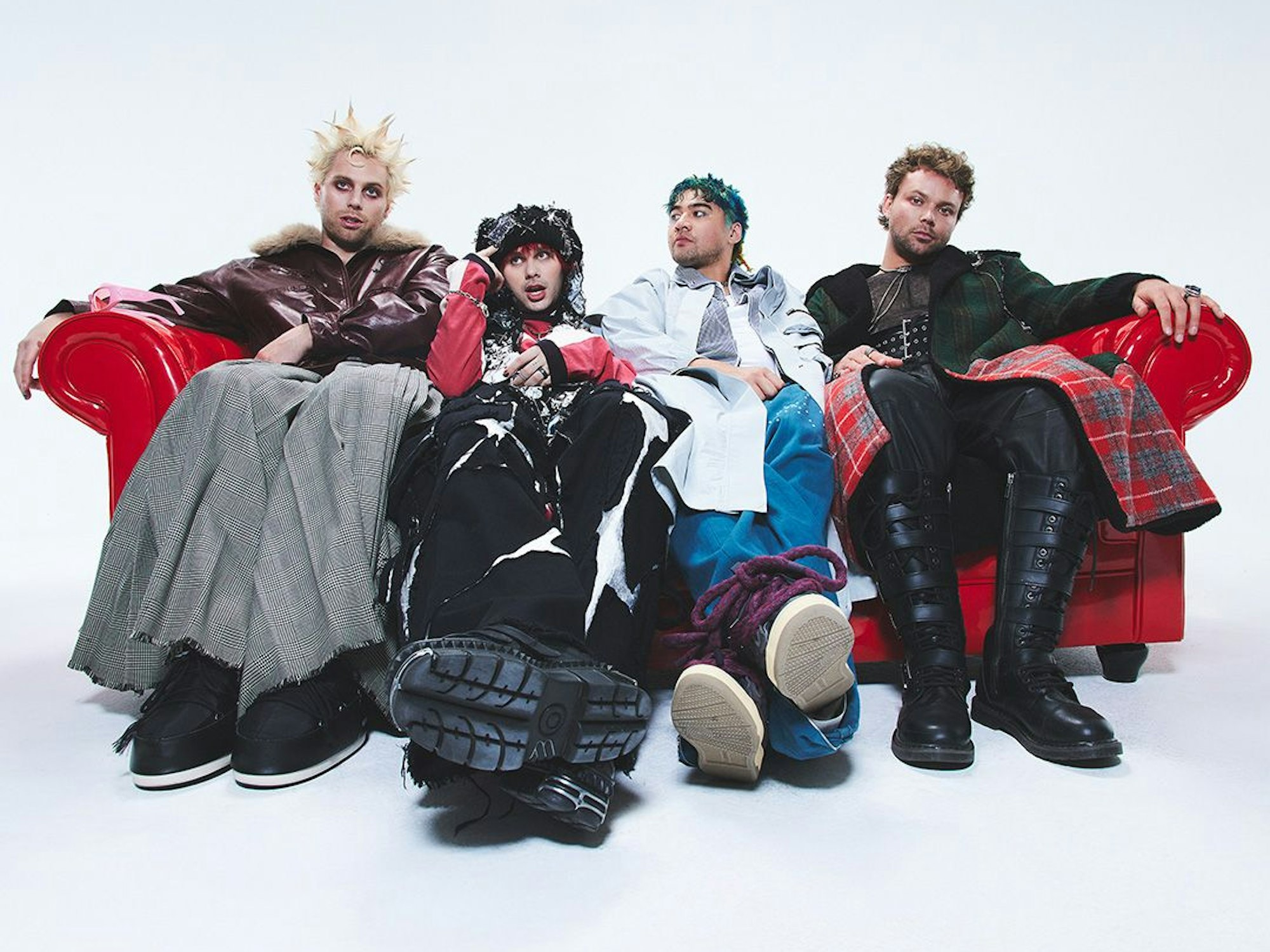 Die Band 5 Seconds of Summer sitzt auf einem Sofa.