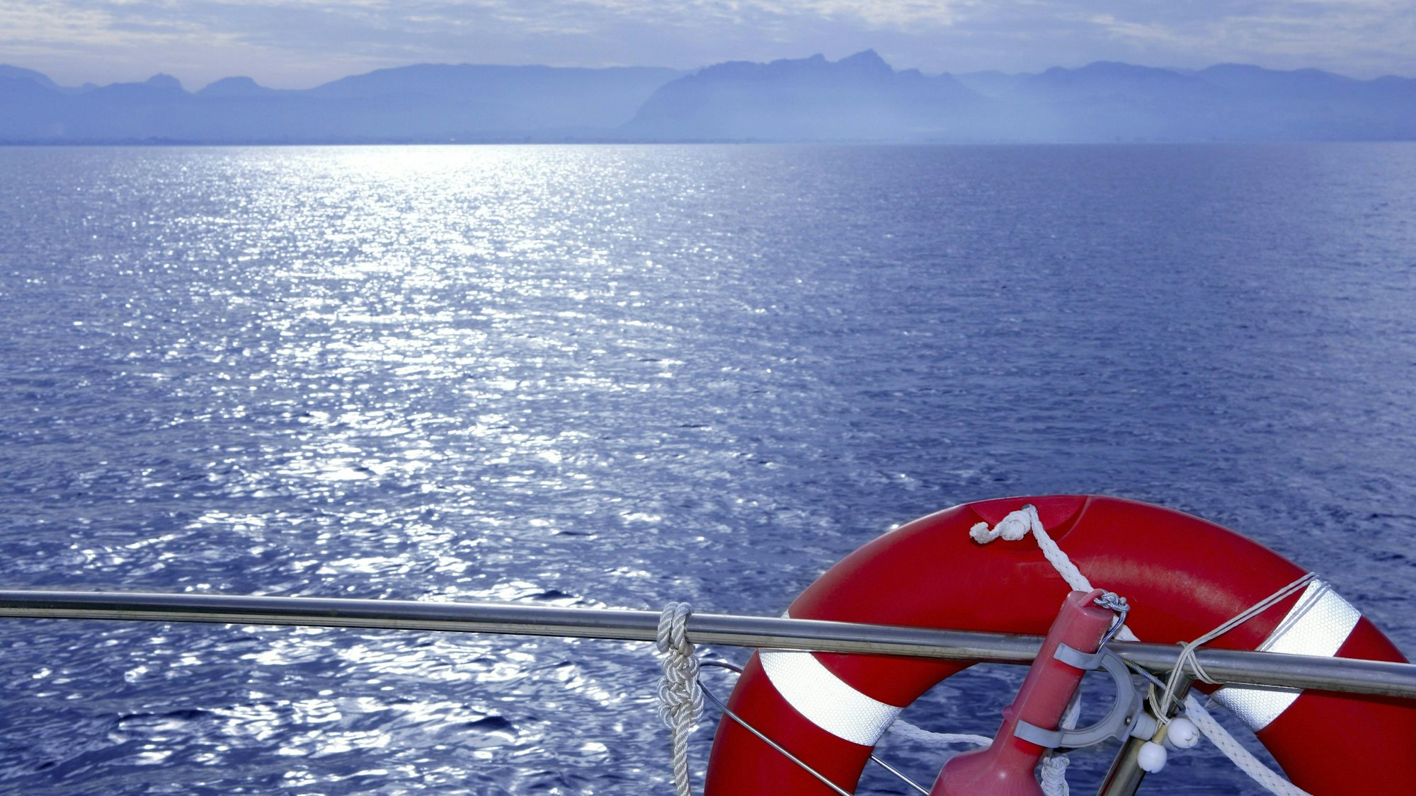 Roter Rettungsring an Bord eines Schiffes (Symbolbild). Vor Mallorca rettete die Besatzung eines Kreuzfahrtschiffes am Sonntag Migrantinnen und Migranten in Seenot.