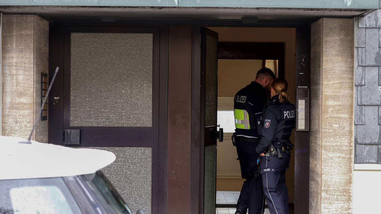 Polizisten stehen im Hauseingang eines Gebäudes, das im Zusammenhang mit einer Razzia gegen organisierte Kriminalität steht. Bei dem Einsatz hat es nach Angaben der Staatsanwaltschaft mehrere Waffenfunde gegeben.