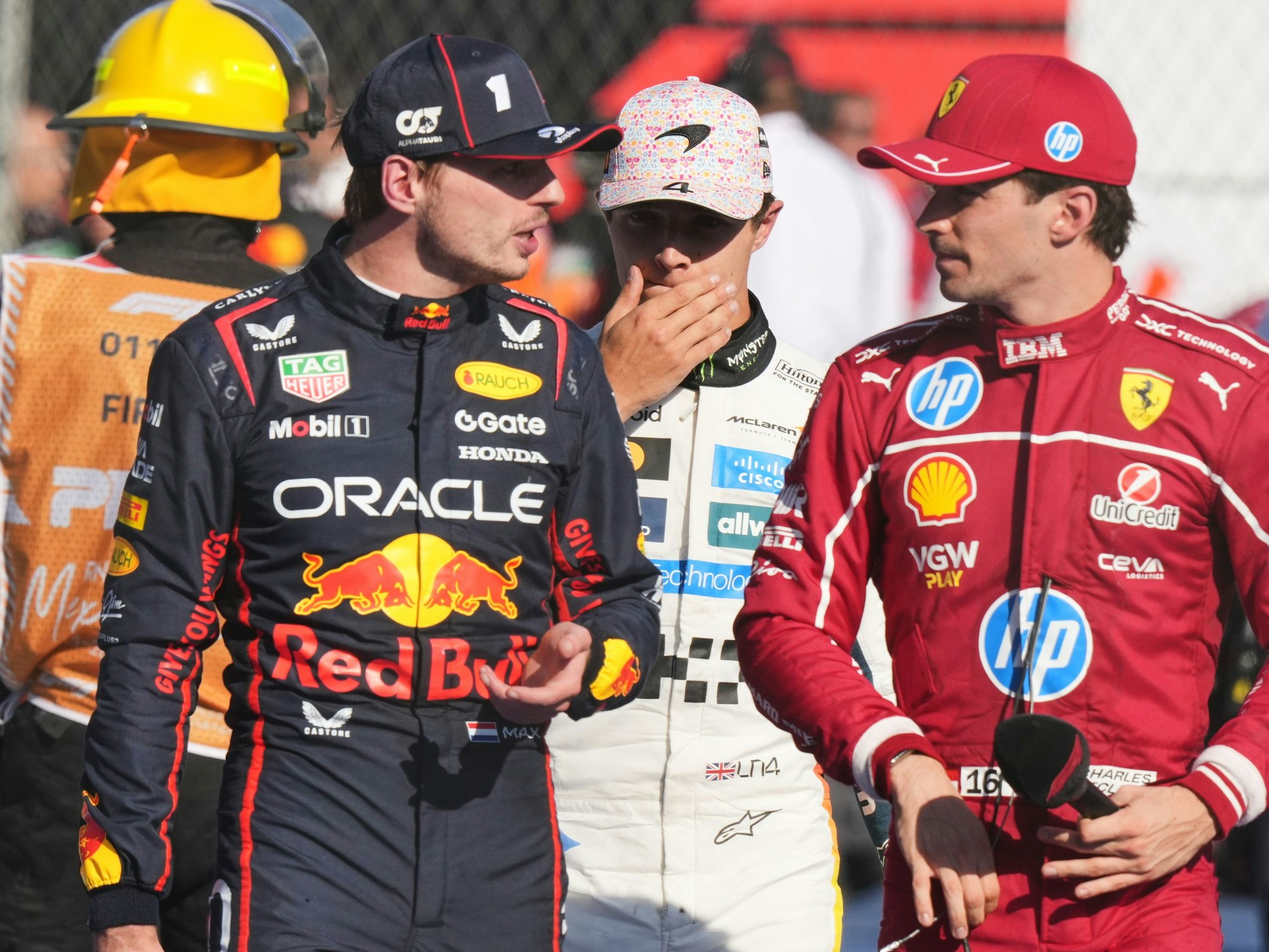 Red Bull-Pilot Max Verstappen unterhält sich mit Ferrari-Pilot Charles Leclerc nach dem Rennen. Dahinter geht Lando Norris.