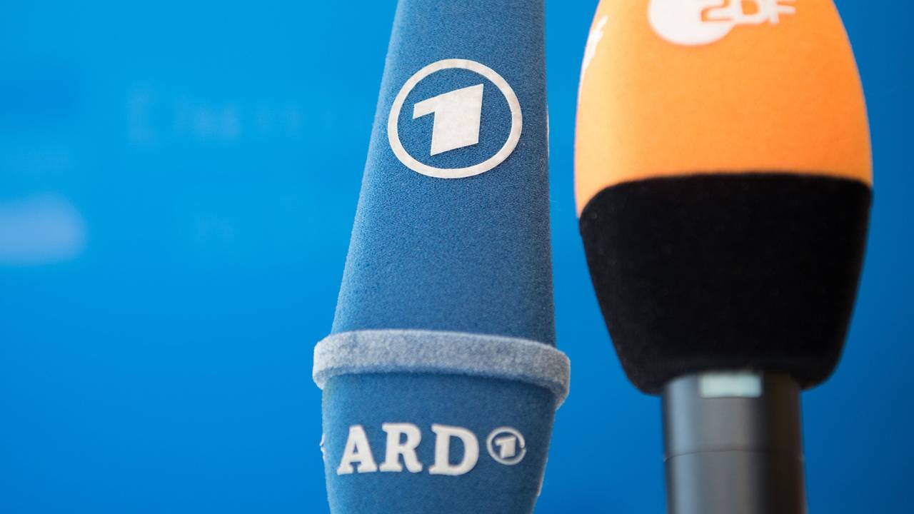 Die Mikrofone von ARD und ZDF sind vor einer Pressekonferenz nebeneinander aufgestellt.