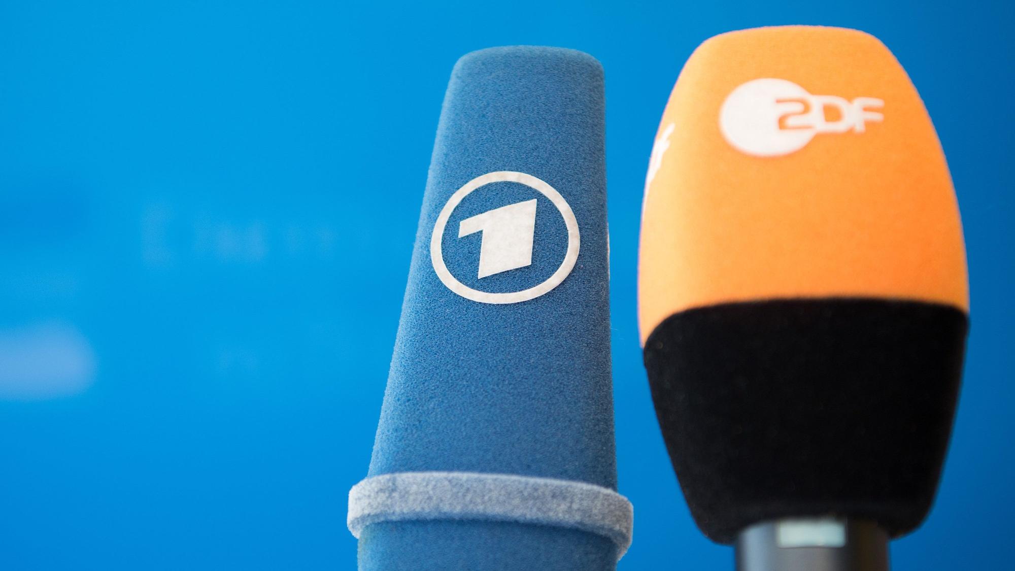 Die Mikrofone von ARD und ZDF sind vor einer Pressekonferenz nebeneinander aufgestellt.