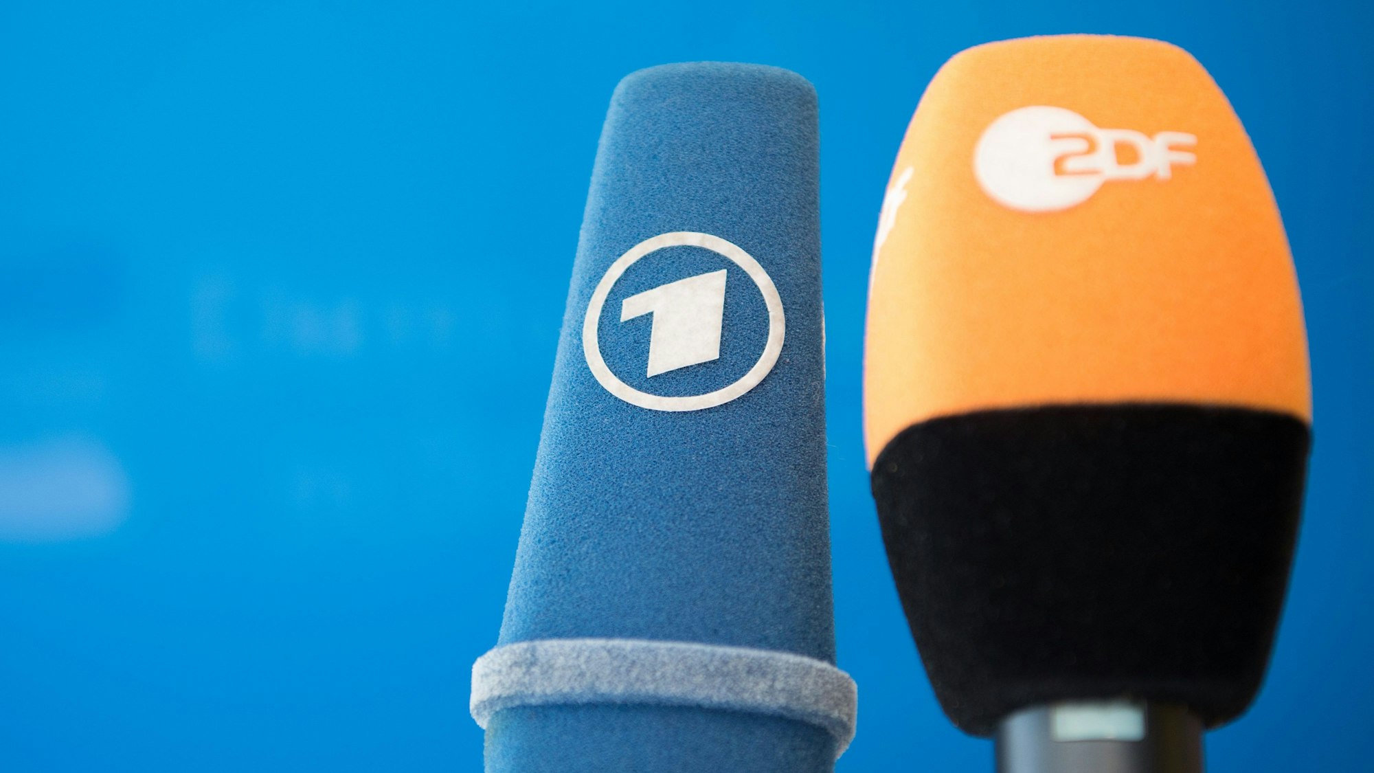 Die Mikrofone von ARD und ZDF sind vor einer Pressekonferenz nebeneinander aufgestellt.