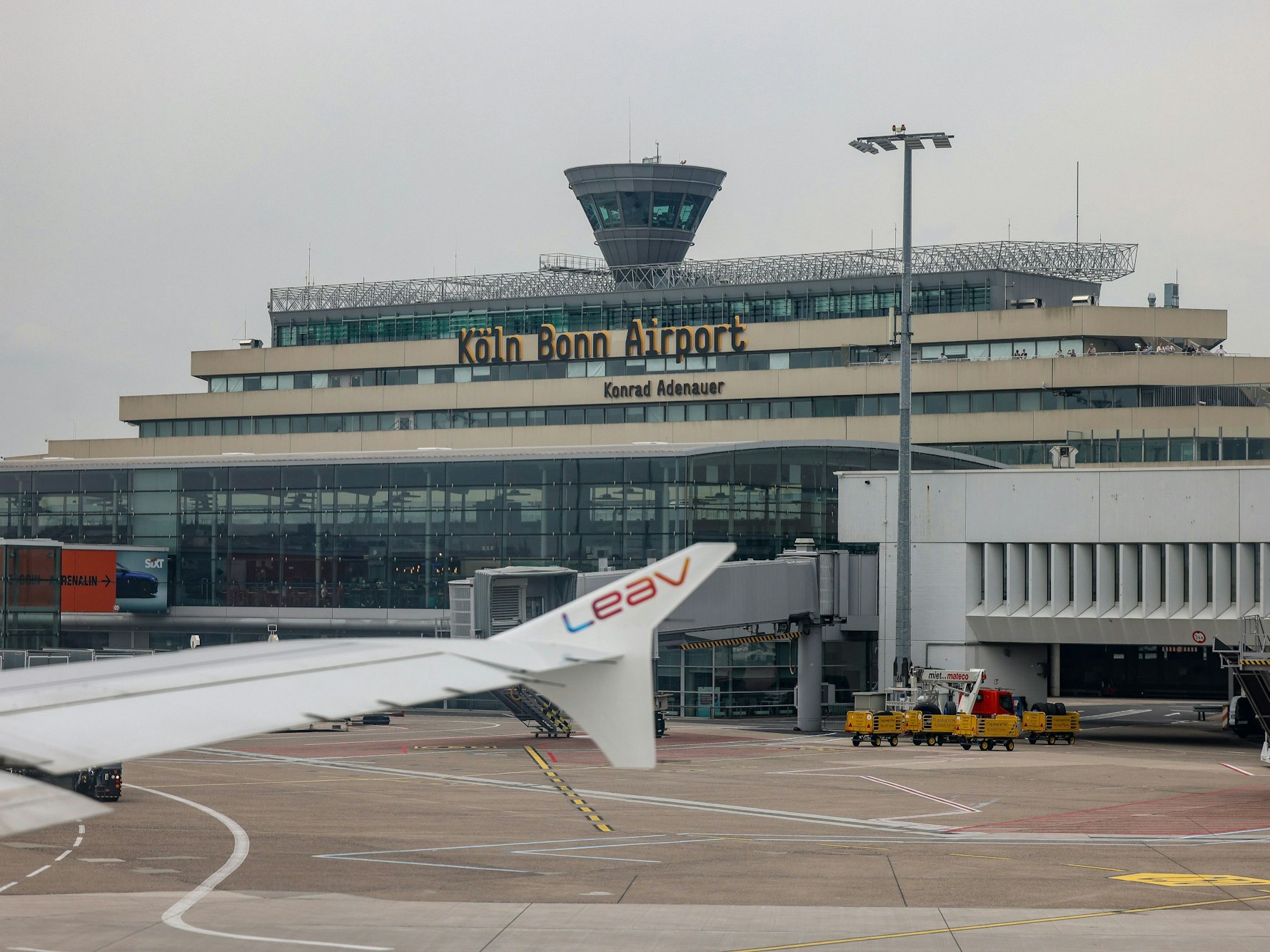 Ein Flugzeug steht auf dem Rollfeld vor dem Hauptgebäude des Flughafen Köln/Bonn „Konrad Adenauer“