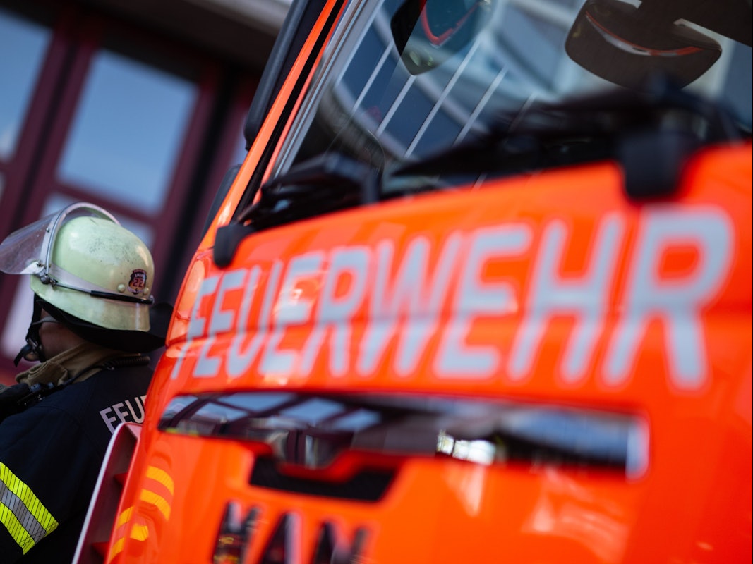 Ein Feuerwehrmann steht neben einem Feuerwehrauto