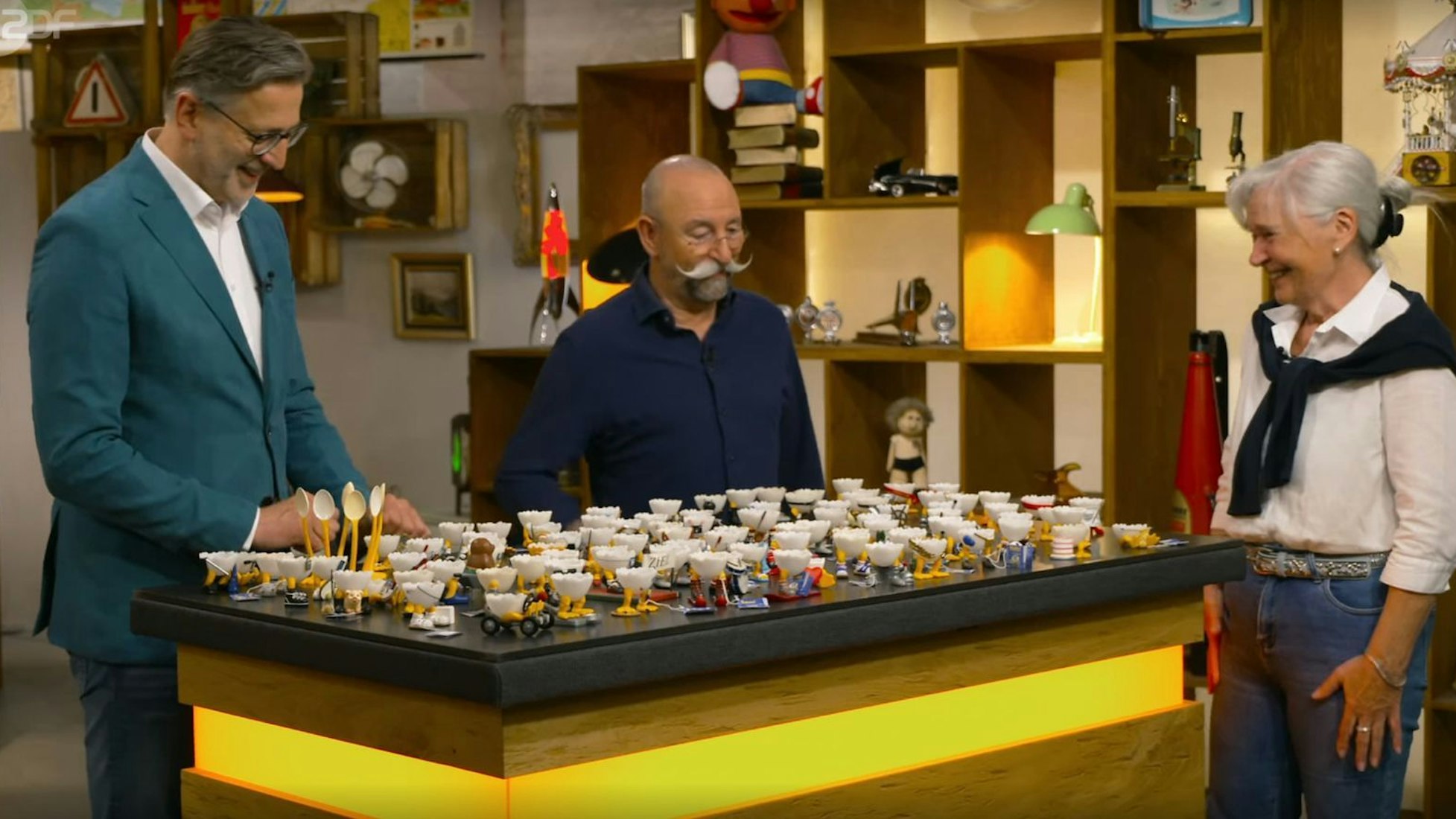 „Eieiei!“ „Horst Lichter (Mitte) war von der Kollektion sofort beeindruckt, die Kandidatin Gisela Detlev Kümmel zur Expertise überlassen hatte. (Bild: ZDF)