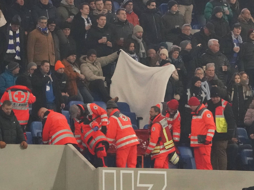 Ein Fan wird auf der Tribüne medizinisch versorgt.