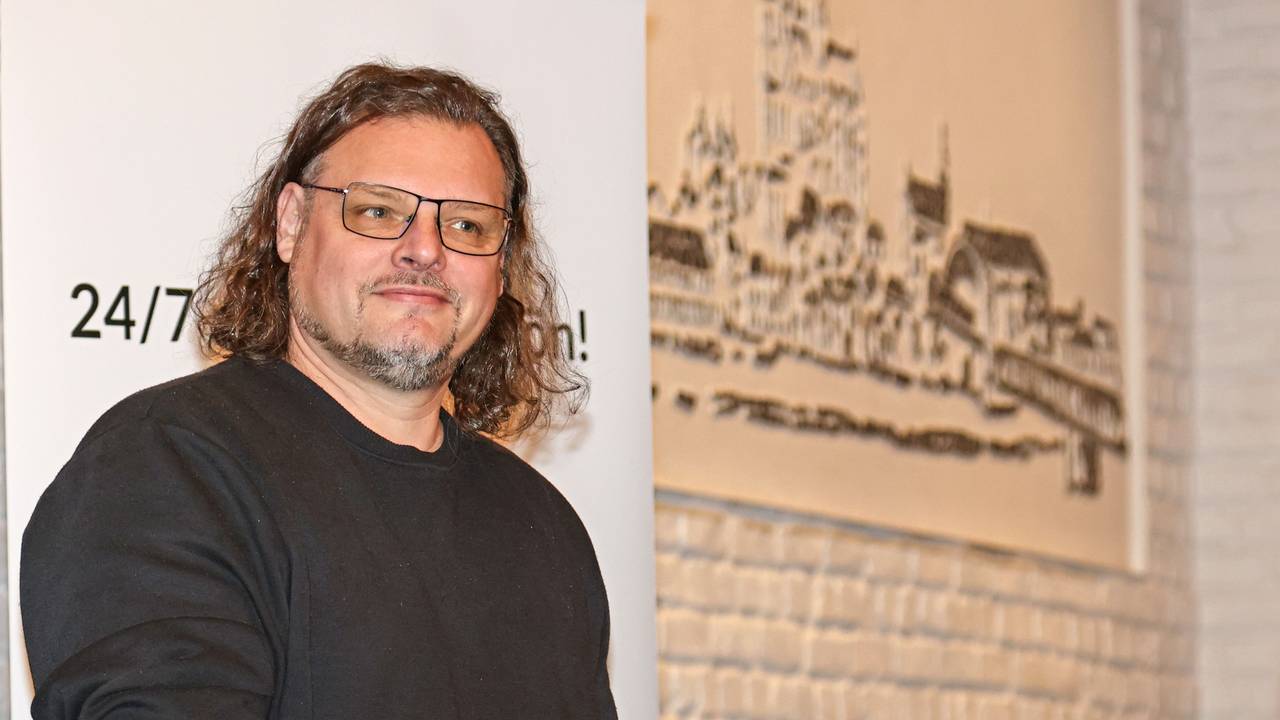 Sänger Micha Hirsch steht am Stehpult, mit dem Mikro in der Hand.