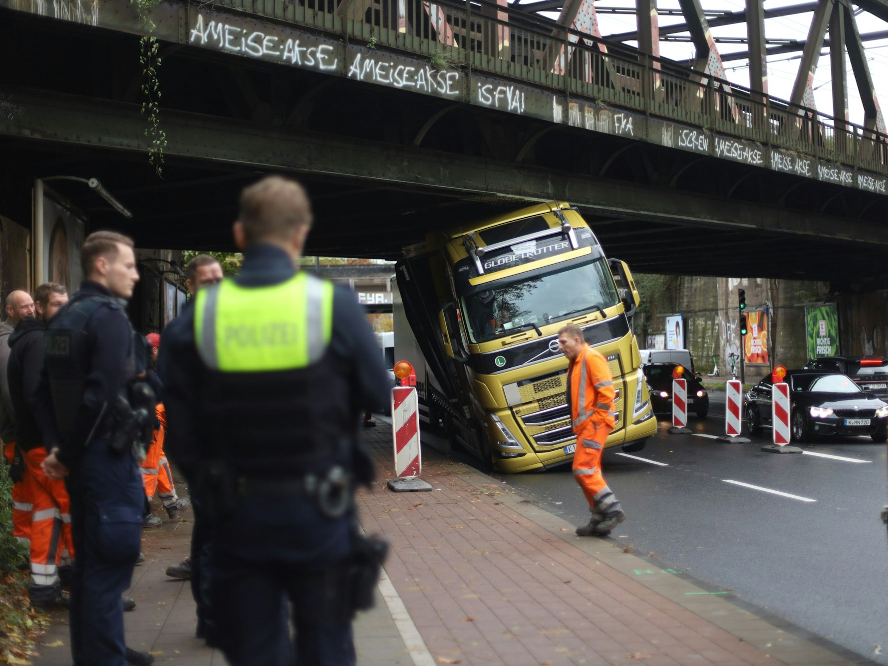 Ein Lkw hängt mit dem Führerhaus unter einer Brücke fest.