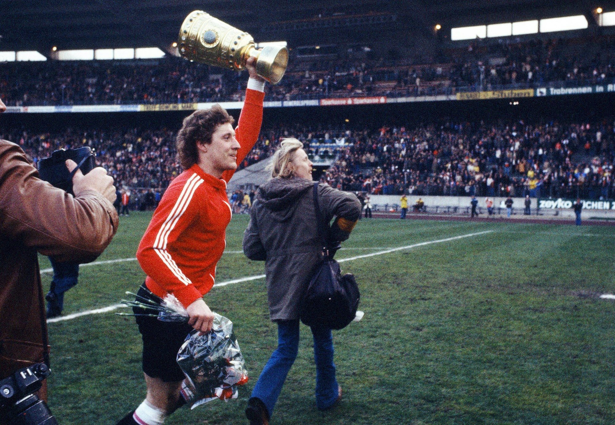 Toni Schumacher vom 1. FC Köln rennt mit dem DFB-Pokal durch das Schalker Parkstadion. (Archivfoto)