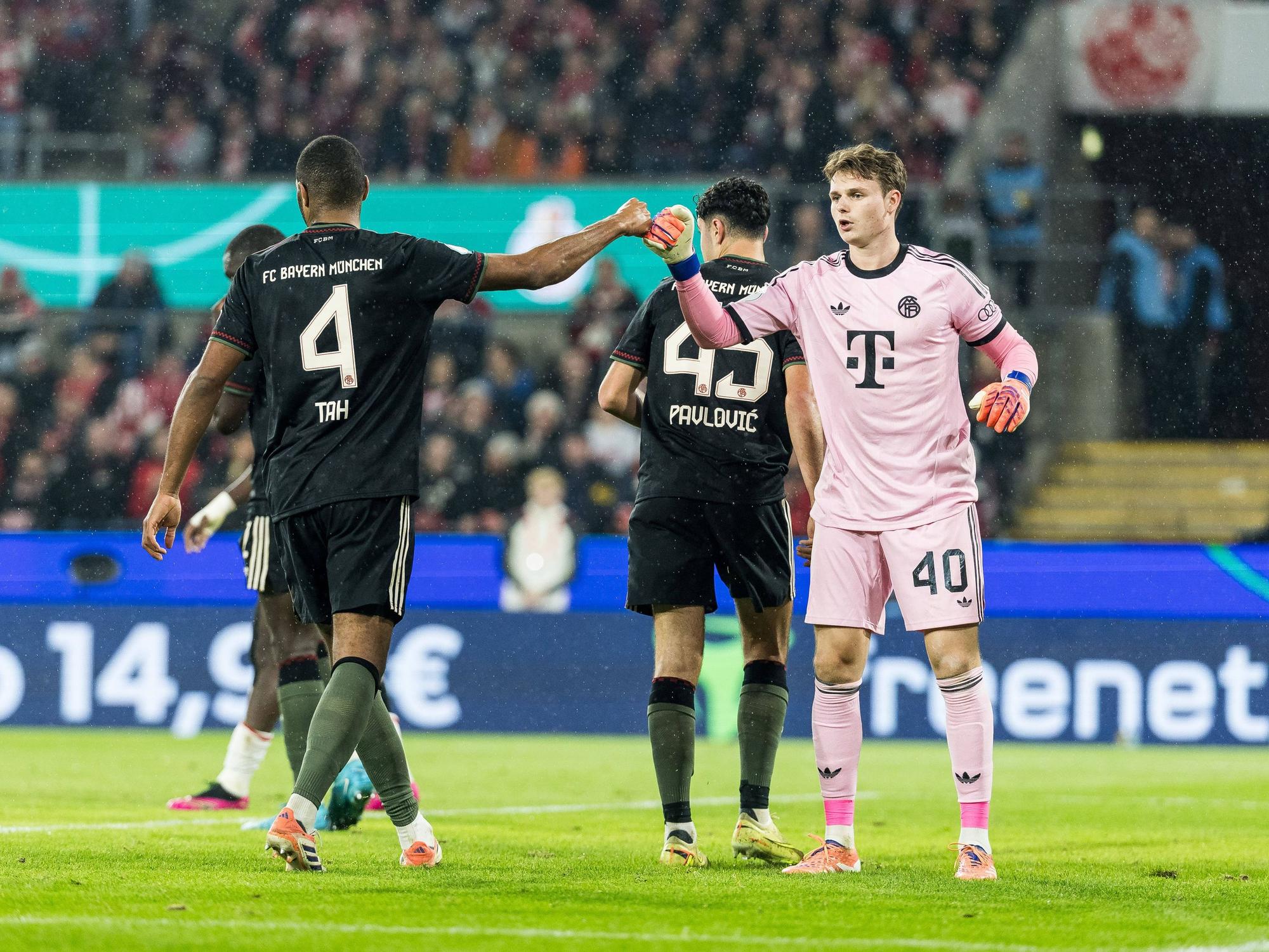 Jonas Urbig und Jonathan Tah klatschen sich ab.