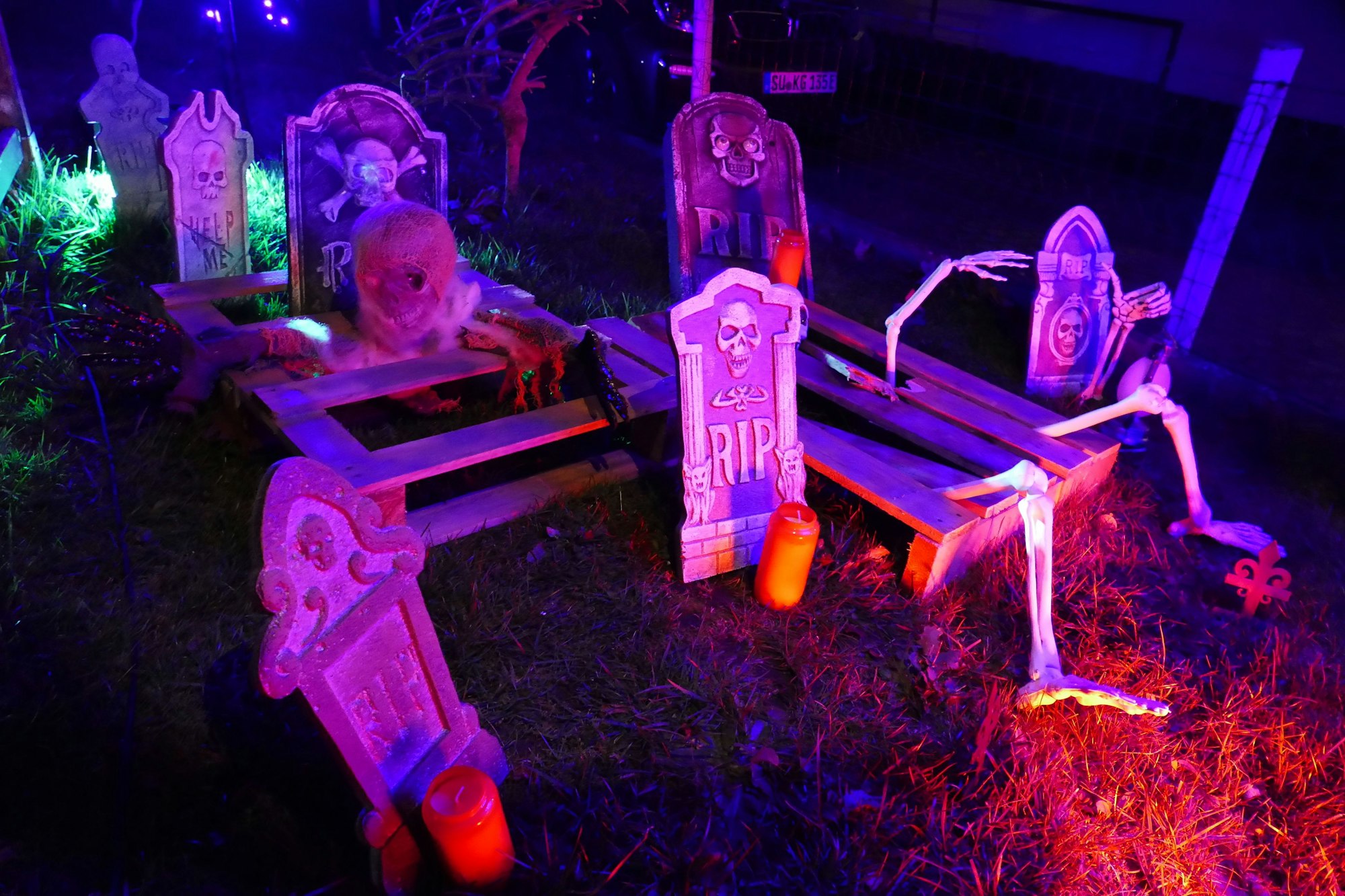 Ein gruselig dekorierter Garten für Halloween mit Skeletten und Kürbissen.