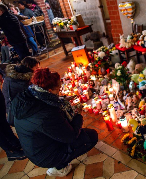 Besucher des Trauergottesdienstes zum Abschied des achtjährigen Fabian stellen am Eingang zur Marienkirche zwischen Plüschtieren Kerzen auf.
