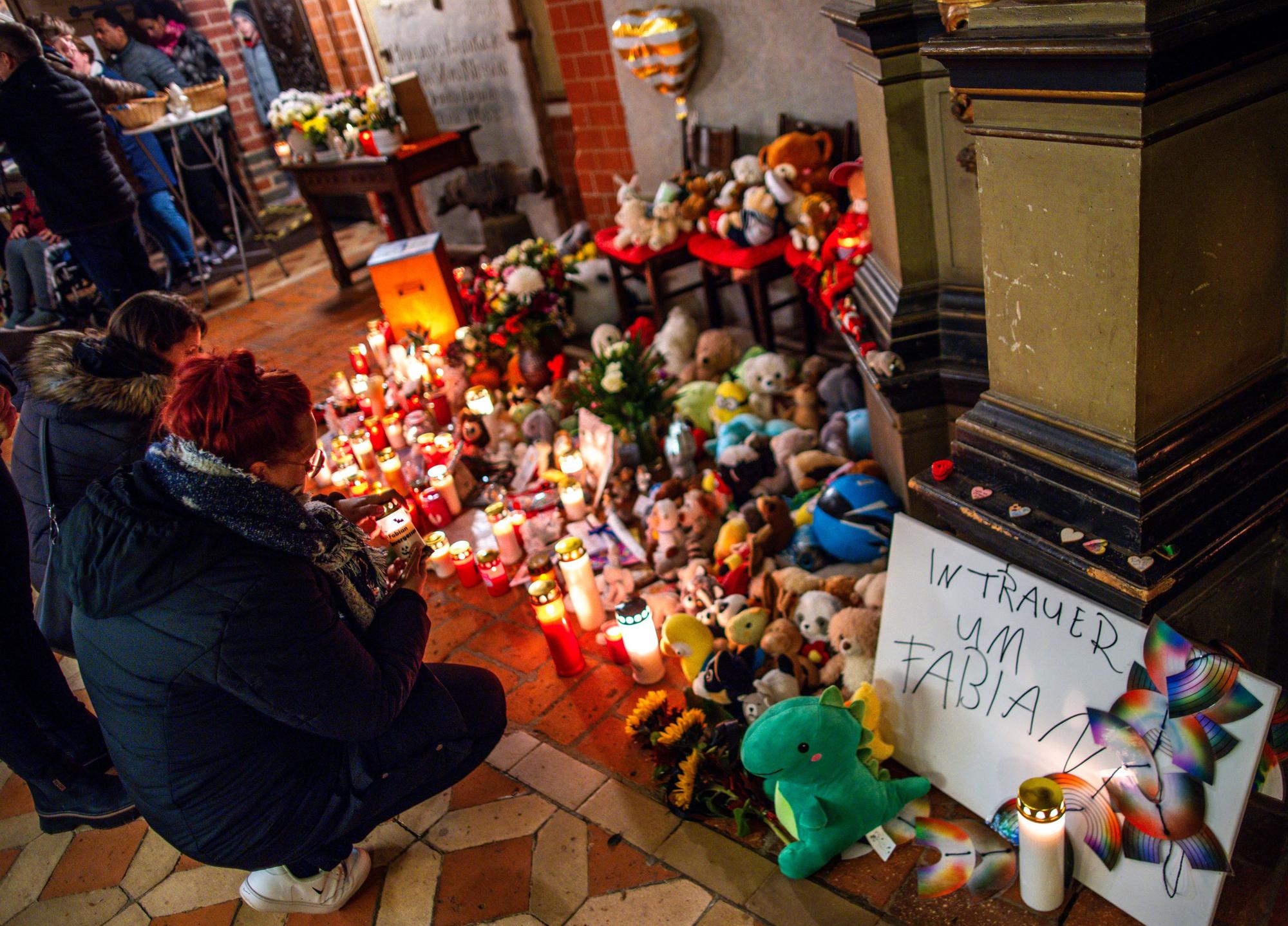 Besucher des Trauergottesdienstes zum Abschied des achtjährigen Fabian stellen am Eingang zur Marienkirche zwischen Plüschtieren Kerzen auf.