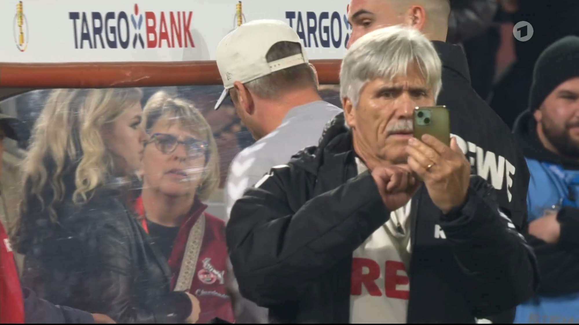 Der Kölner Mannschaftsarzt Dr. Peter Schäferhoff fotografiert mit seinem Handy die Choreo im Pokalspiel des 1. FC Köln gegen den FC Bayern.
