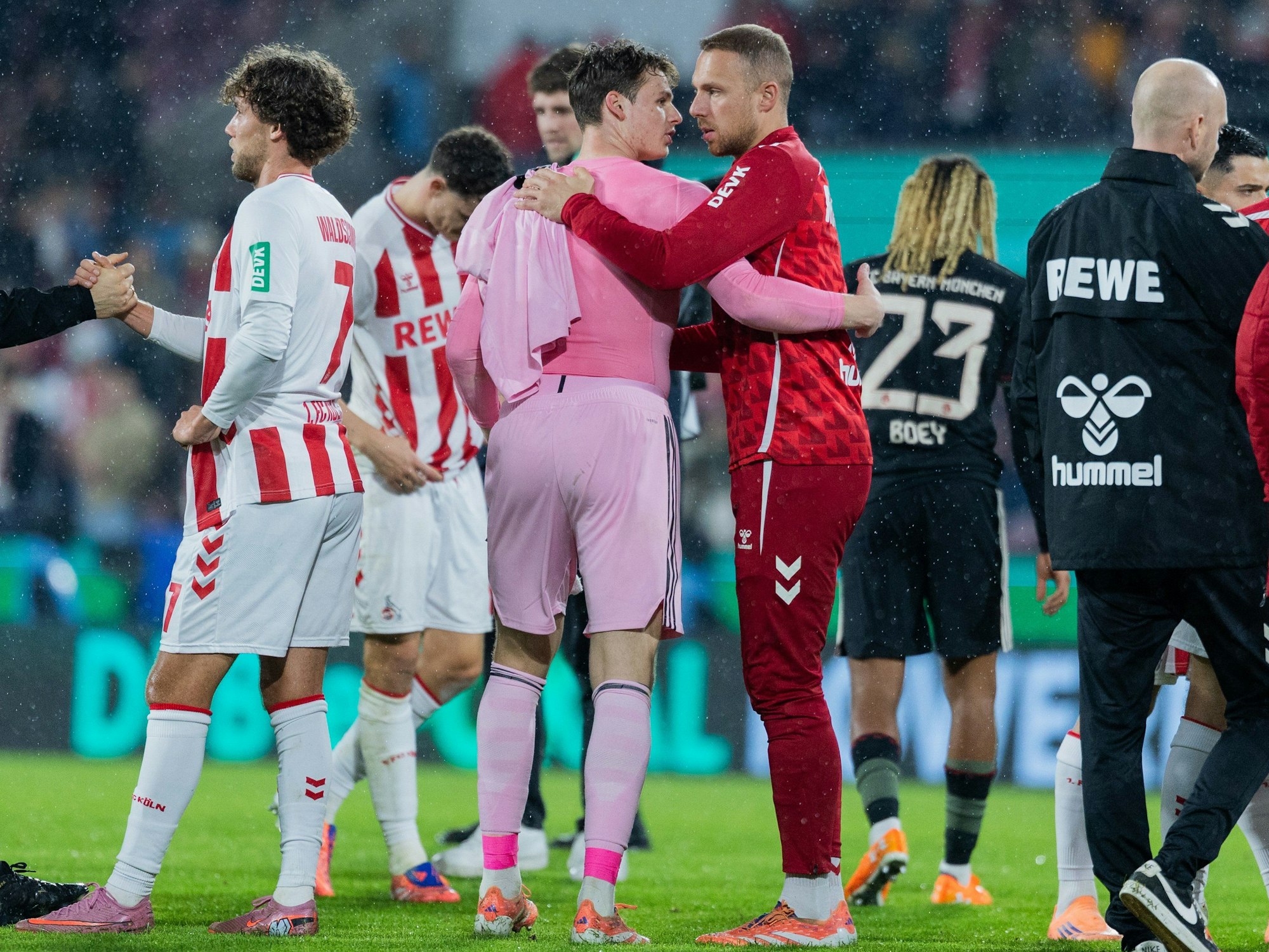 Münchens Torwart Jonas Urbig und Kölns Marvin Schwäbe umarmen sich nach dem Spiel.