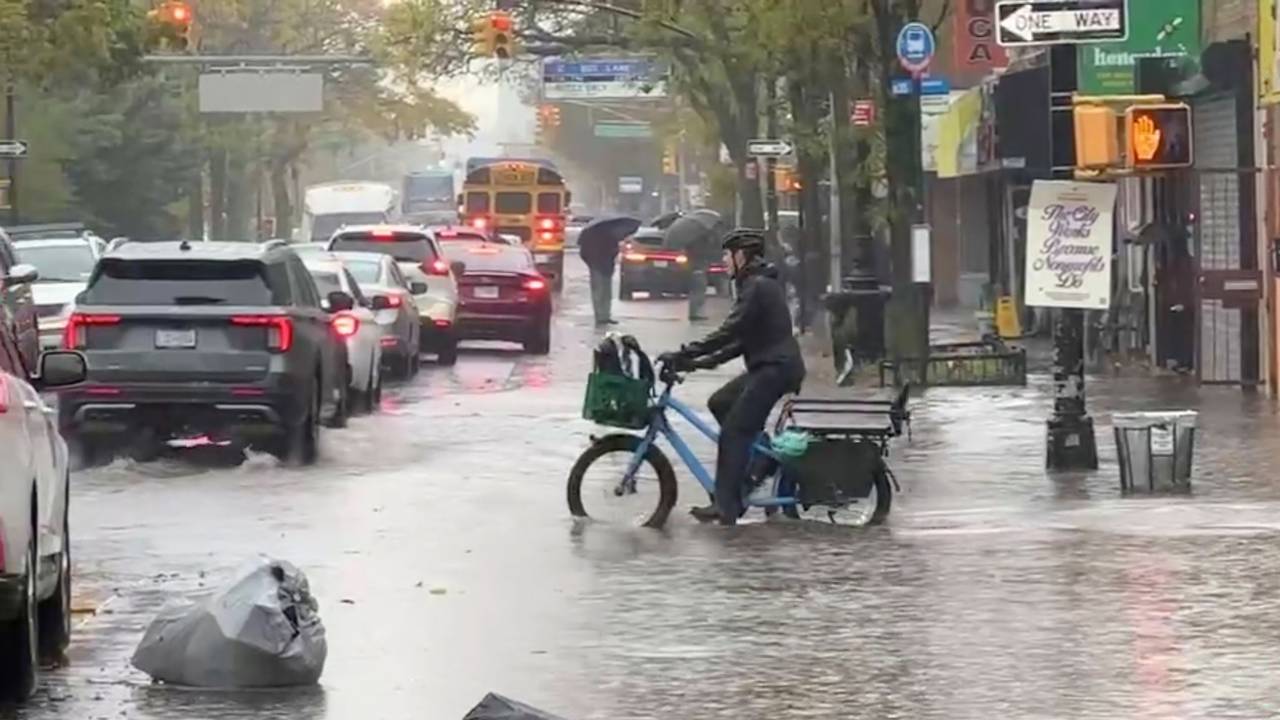 Ein Radfahrer fährt während eines Regenschauers in New York durch die Fluten.