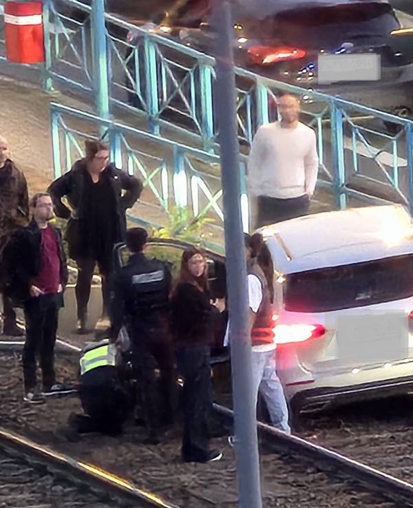 Ein Auto steht im Gleisbett der KVB, mehrere Menschen stehen darum
