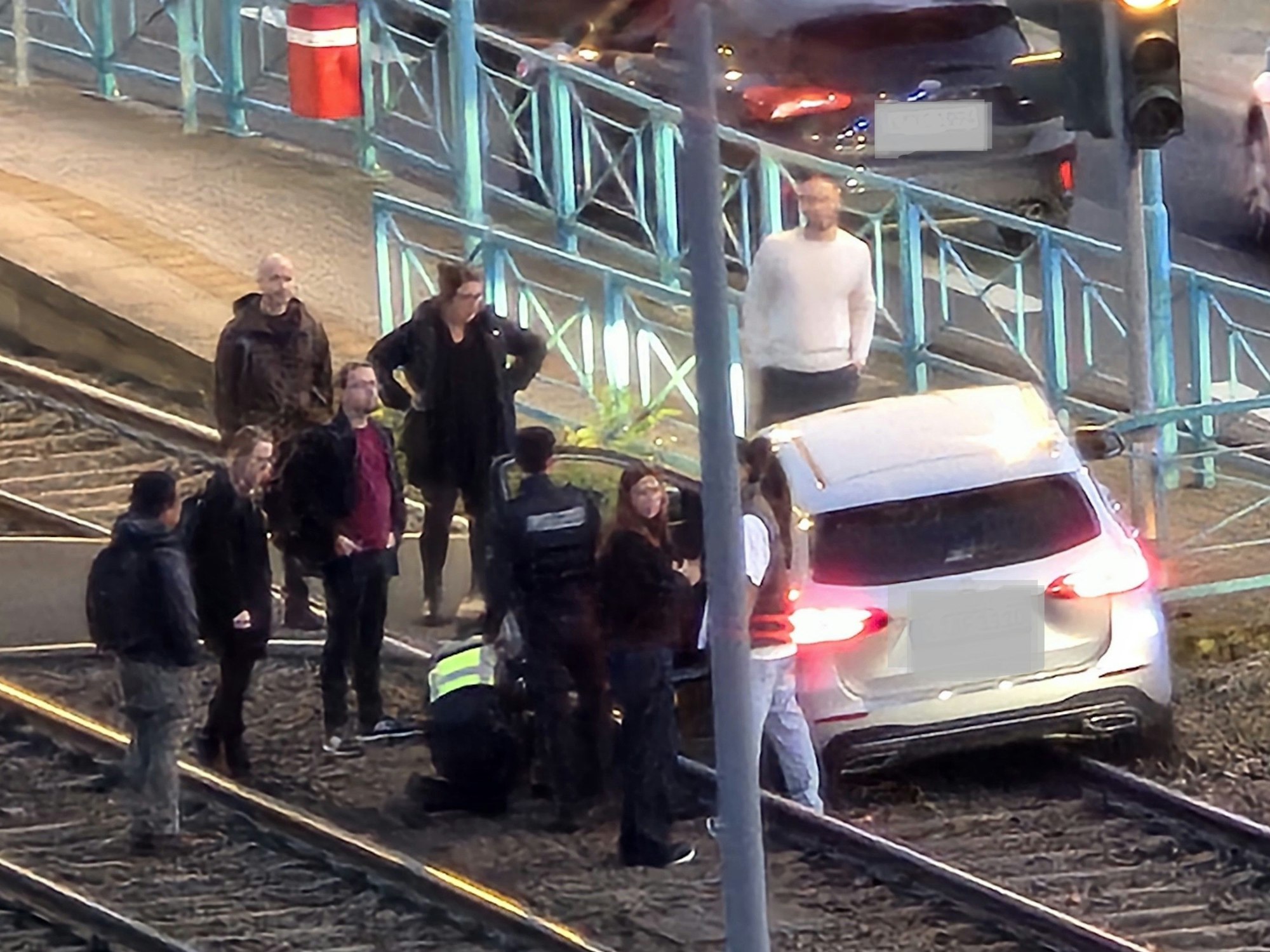 Ein Auto steht im Gleisbett der KVB, mehrere Menschen stehen darum