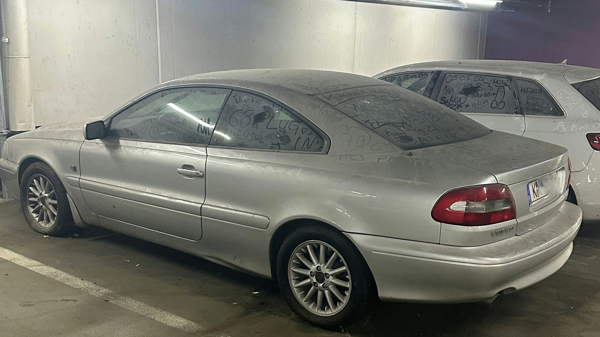 Zwei Autos stehen nebeneinander, beide sind mit einer Staubschicht bedeckt.