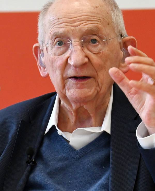 Ein alter Herr mit Hörgerät und weißem Haar gestikuliert und redet