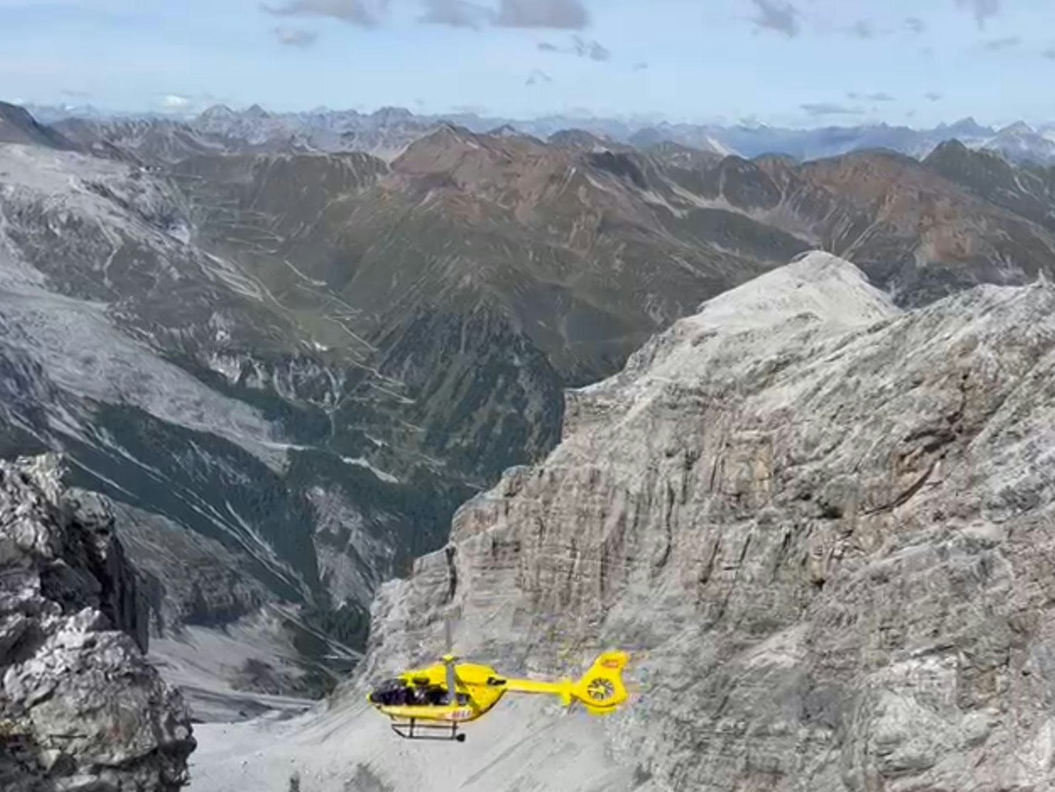 Ein Hubschrauber fliegt über ein Gebirge.