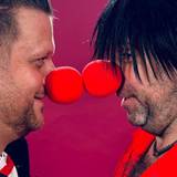 Alex Barth und Ikke Hüftgold stehen sich mit roten Pappnasen gegenüber.