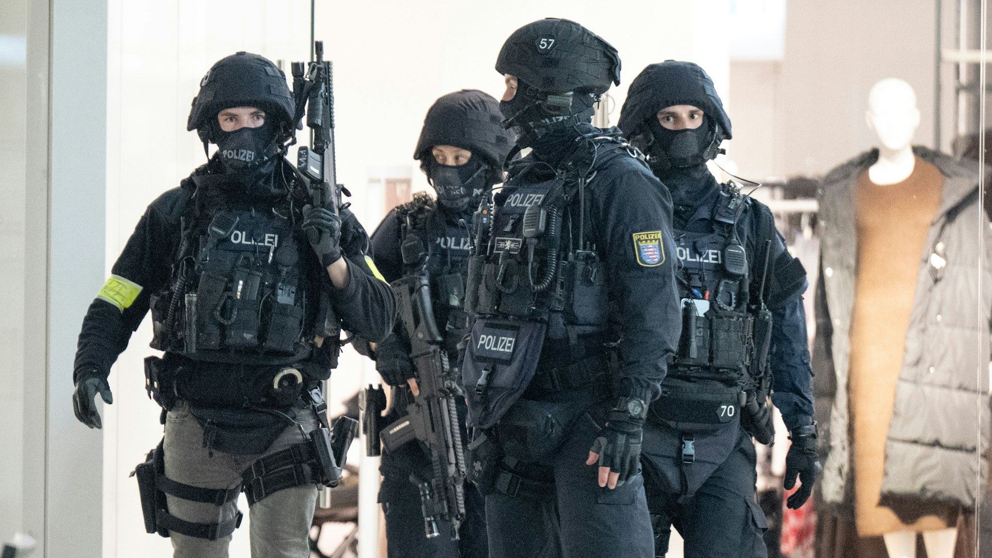 Schwer bewaffnete Polizeikräfte durchkämmen ein Einkaufszentrum.
