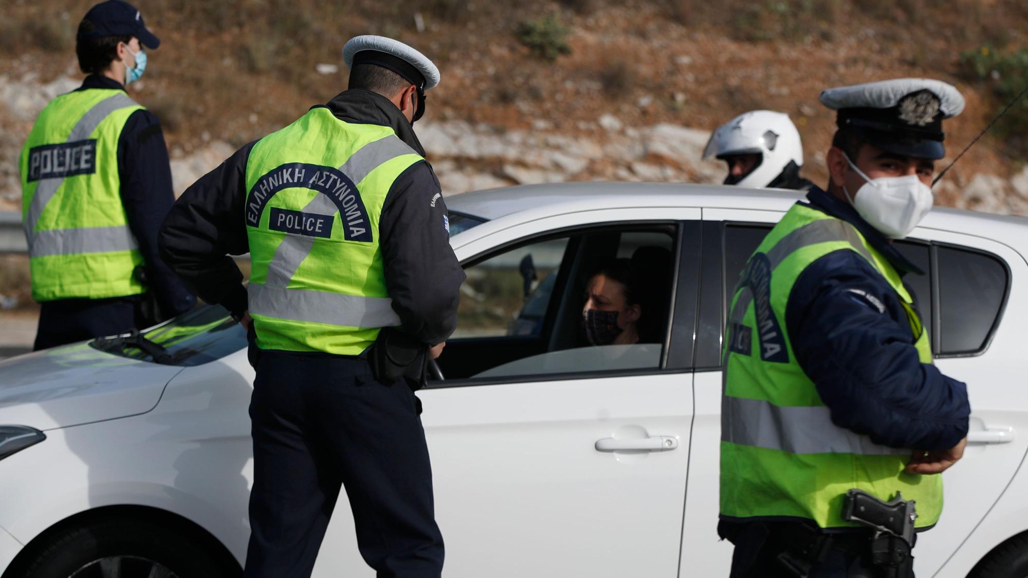 Polizisten überprüfen die Insassen eines Autos.