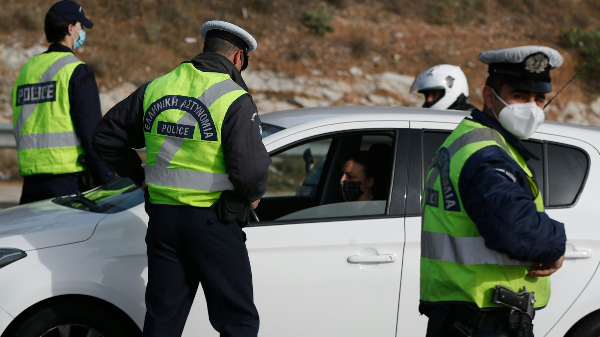 Polizisten überprüfen die Insassen eines Autos.