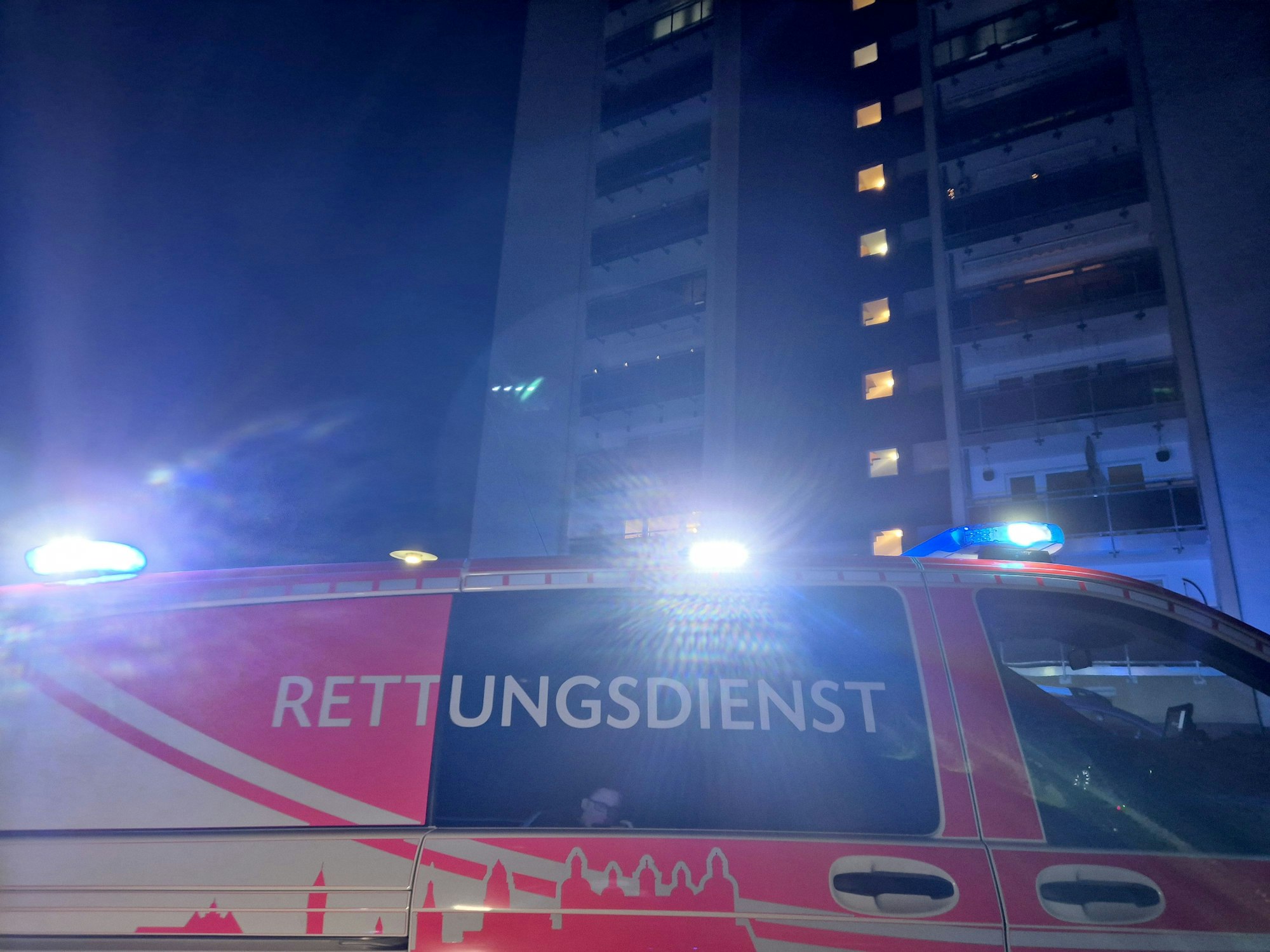 in Fahrzeug des Rettungsdienstes steht vor einem Mehrfamilienhaus. Bei einer Verpuffung in einer Wohnung sind in Bergisch Gladbach drei Menschen verletzt worden - einer von ihnen schwer.