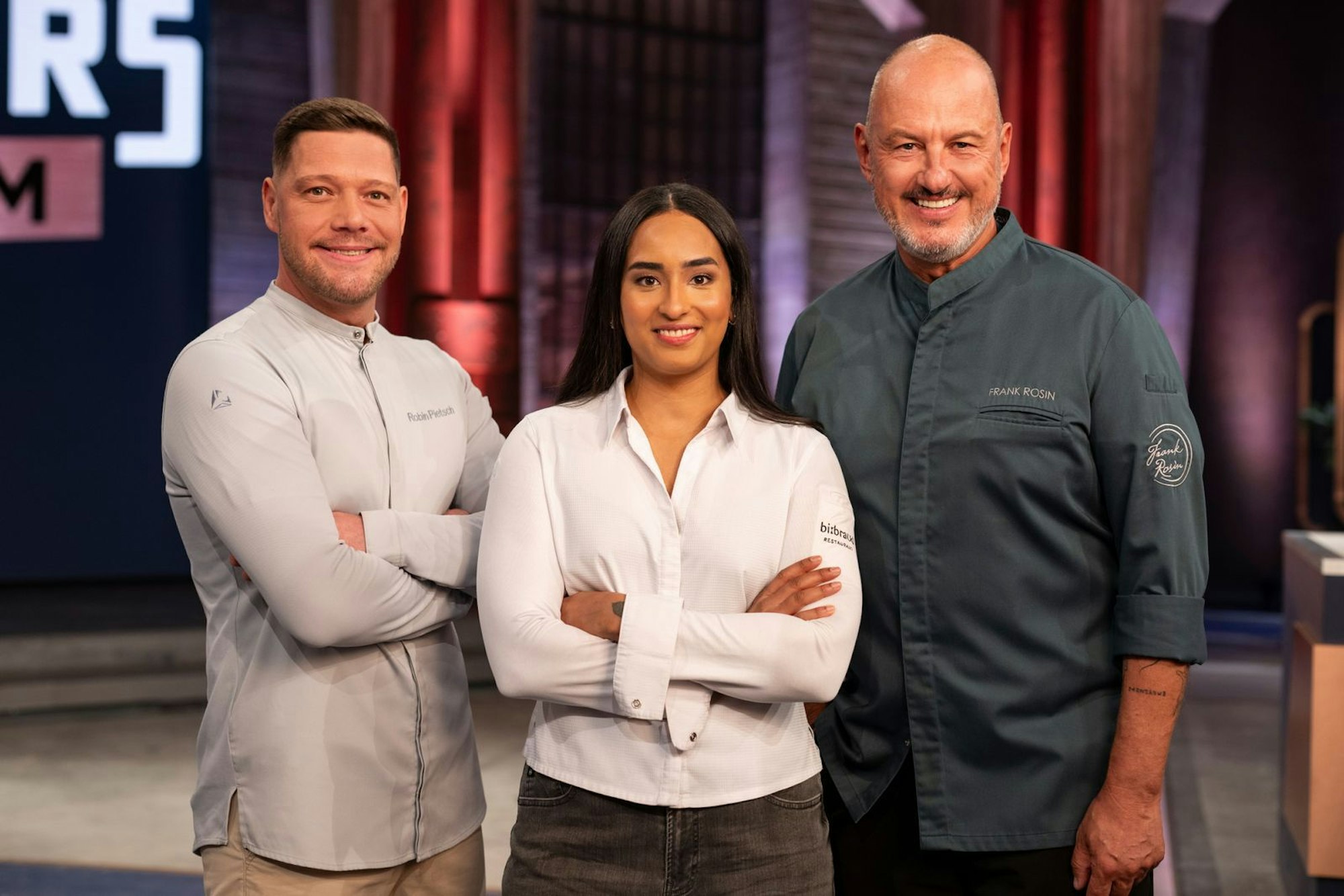 Eine Frau steht zwischen zwei Männern.