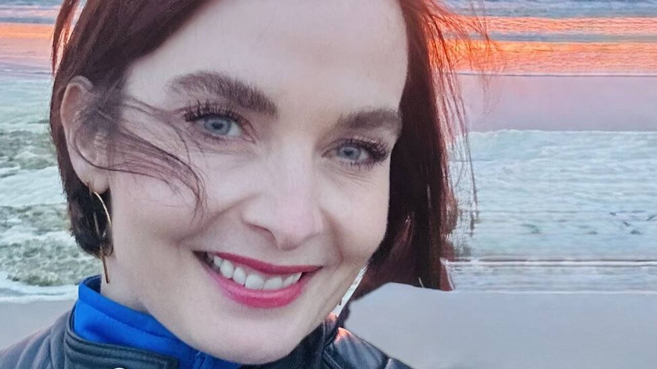 Eine Frau steht vor einem Meer und macht ein Selfie.