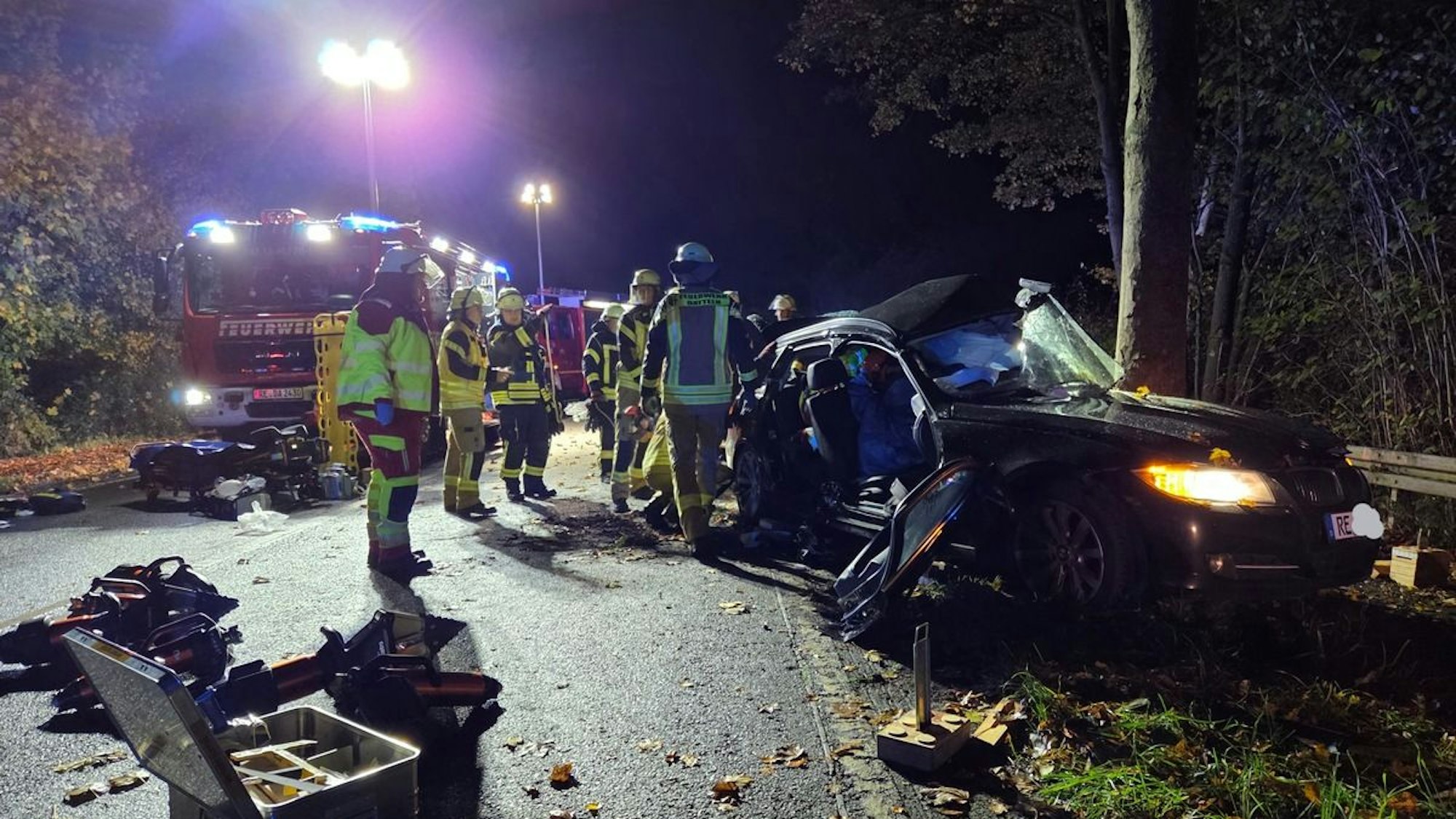 Ein im Graben verunfalltes Auto wird von der Feuerwehr beleuchtet.