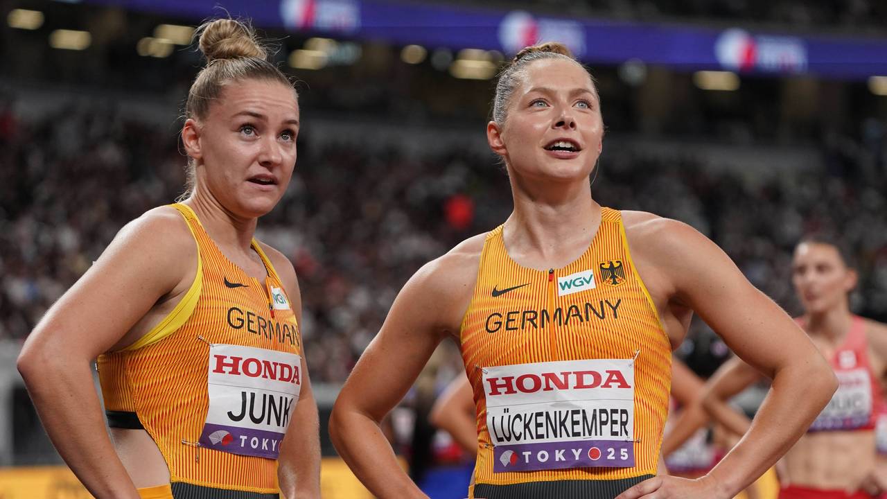Sophia Junk und Gina Lückenkemper schauen kurz nach einem Wettkampf nach oben auf den Bildschirm im Stadion.