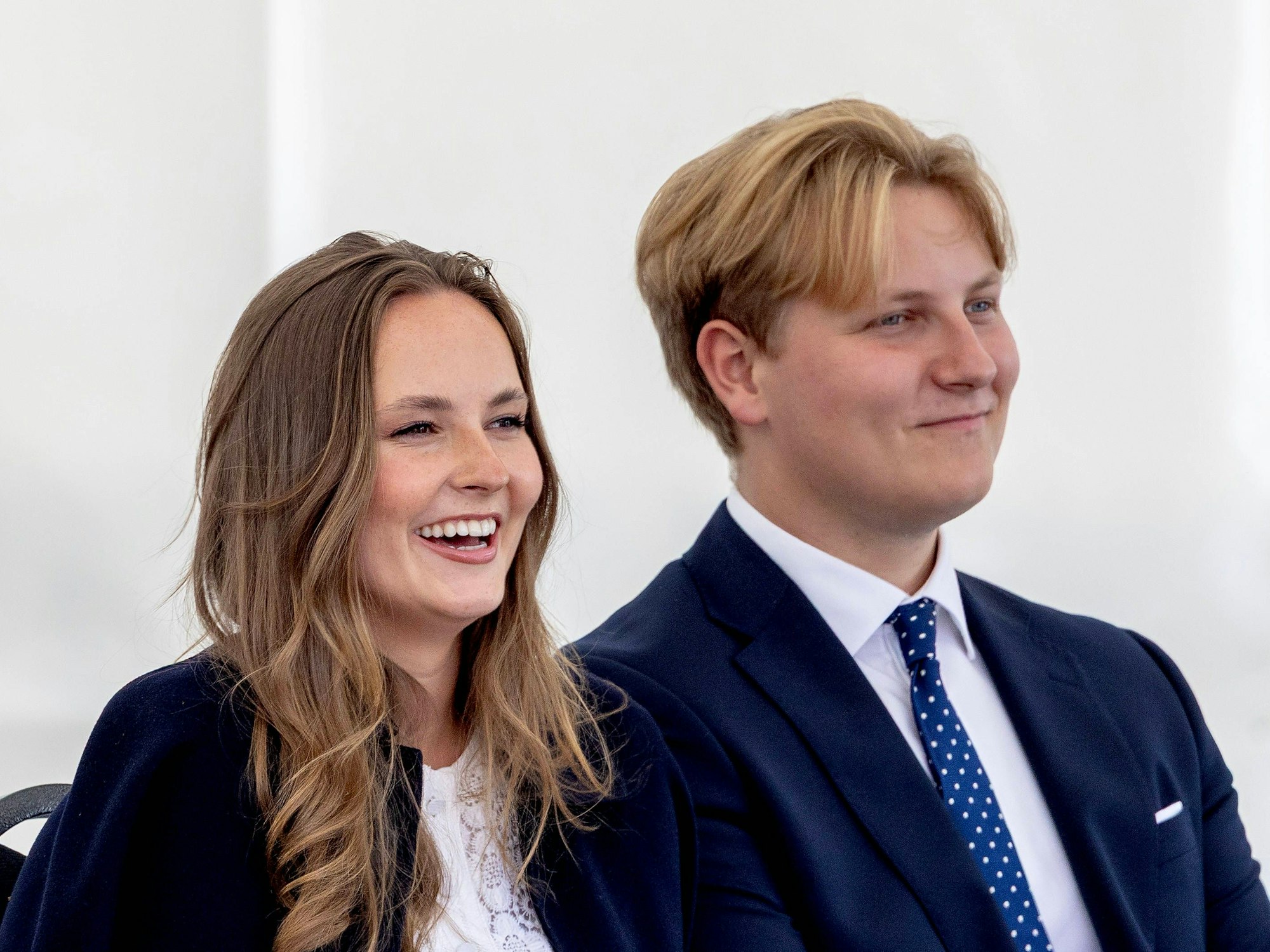 Prinzessin Ingrid Alexandra und Prinz Sverre Magnus von Norwegen sitzen grinsend nebeneinander.