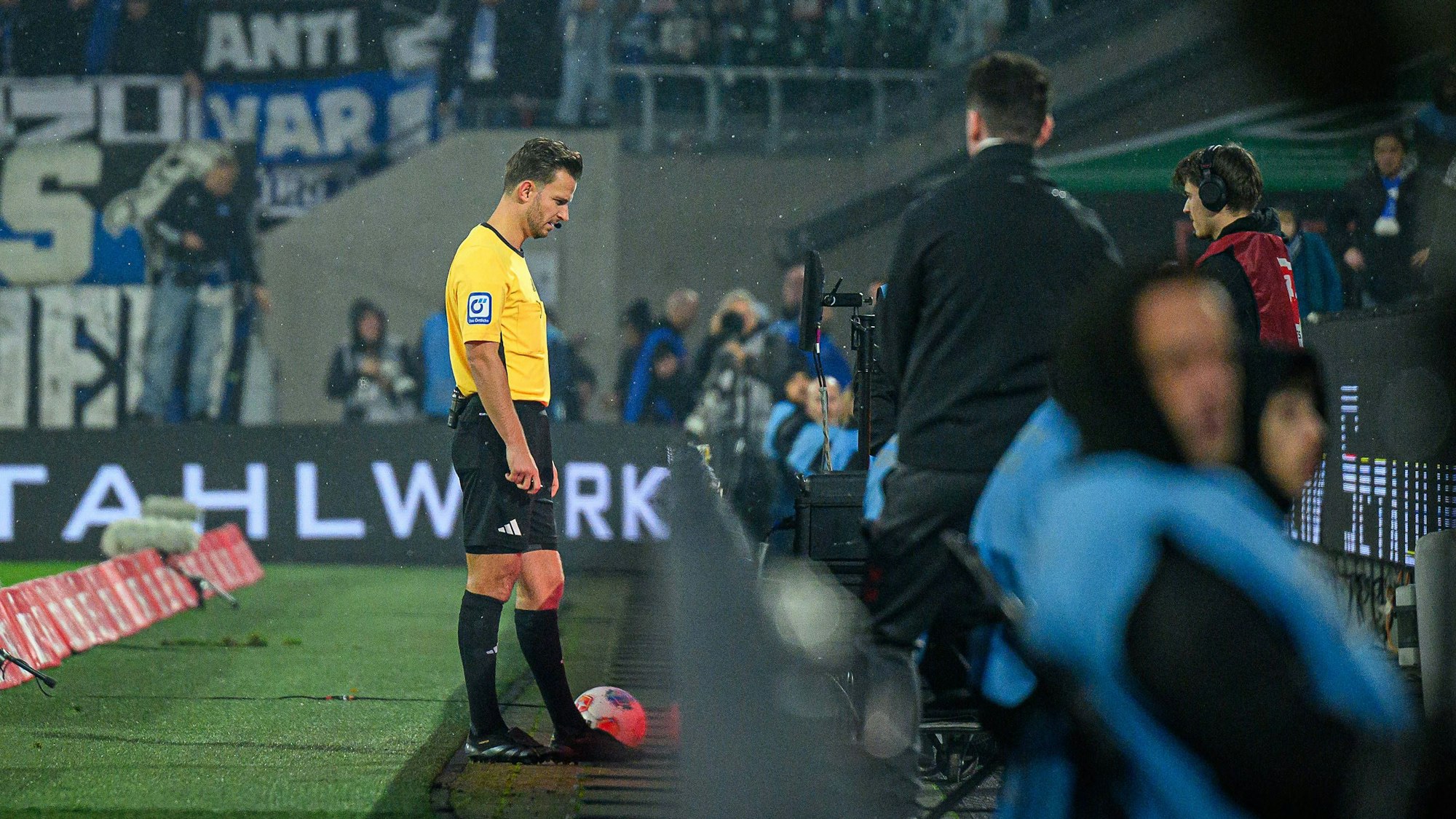 Schiedsrichter Daniel Schlager schaut sich eine Spielszene auf dem Bildschirm an.