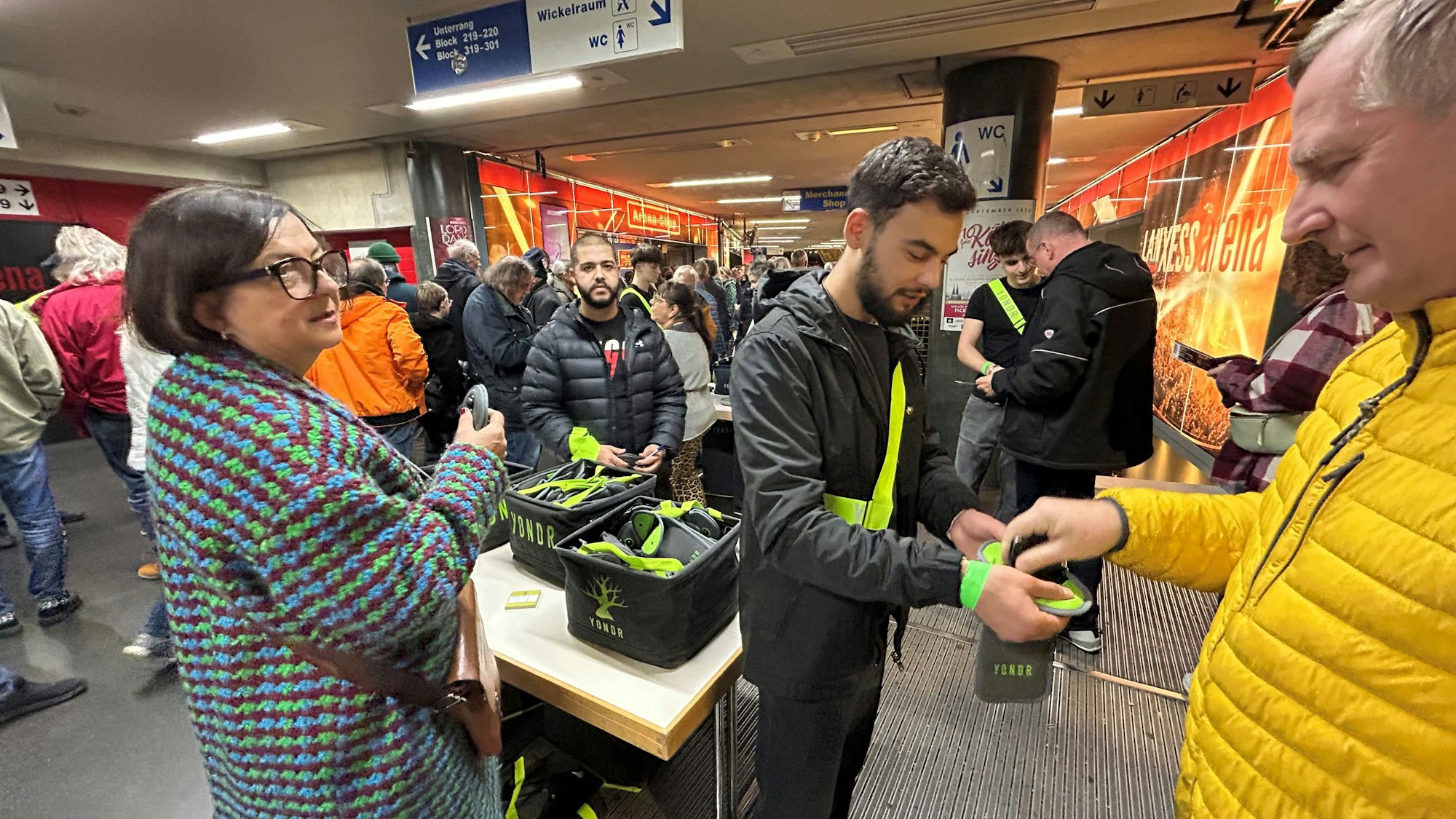 Fans stecken ihre Handys in die Stofftaschen.