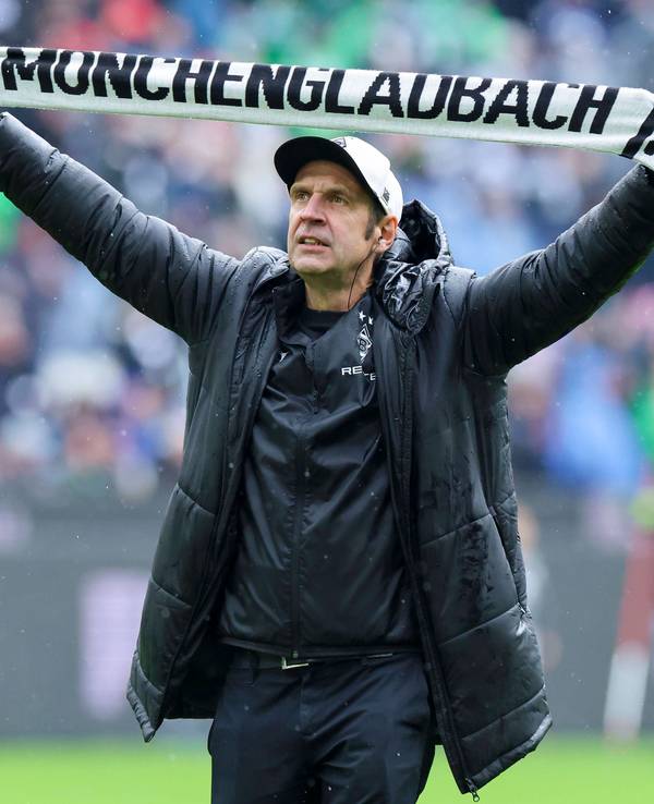 Stadionsprecher Torsten Knippertz steht mit einem Schal von Borussia Mönchengladbach im Stadion.