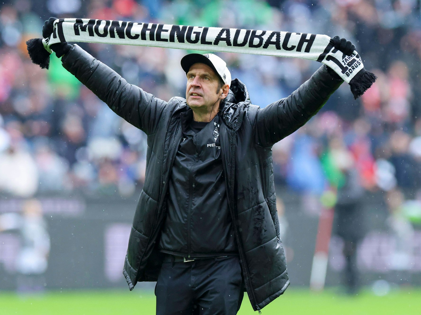 Stadionsprecher Torsten Knippertz steht mit einem Schal von Borussia Mönchengladbach im Stadion.