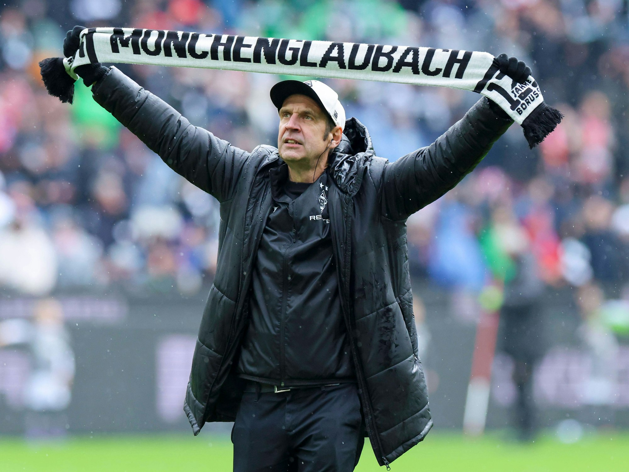 Stadionsprecher Torsten Knippertz steht mit einem Schal von Borussia Mönchengladbach im Stadion.