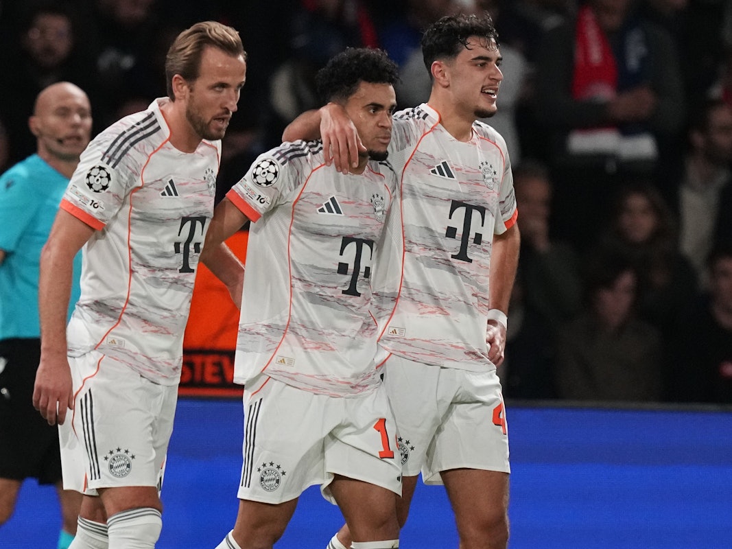 Harry Kane, Luis Diaz und Aleksandar Pavlovic gehen Arm in Arm über den Platz.