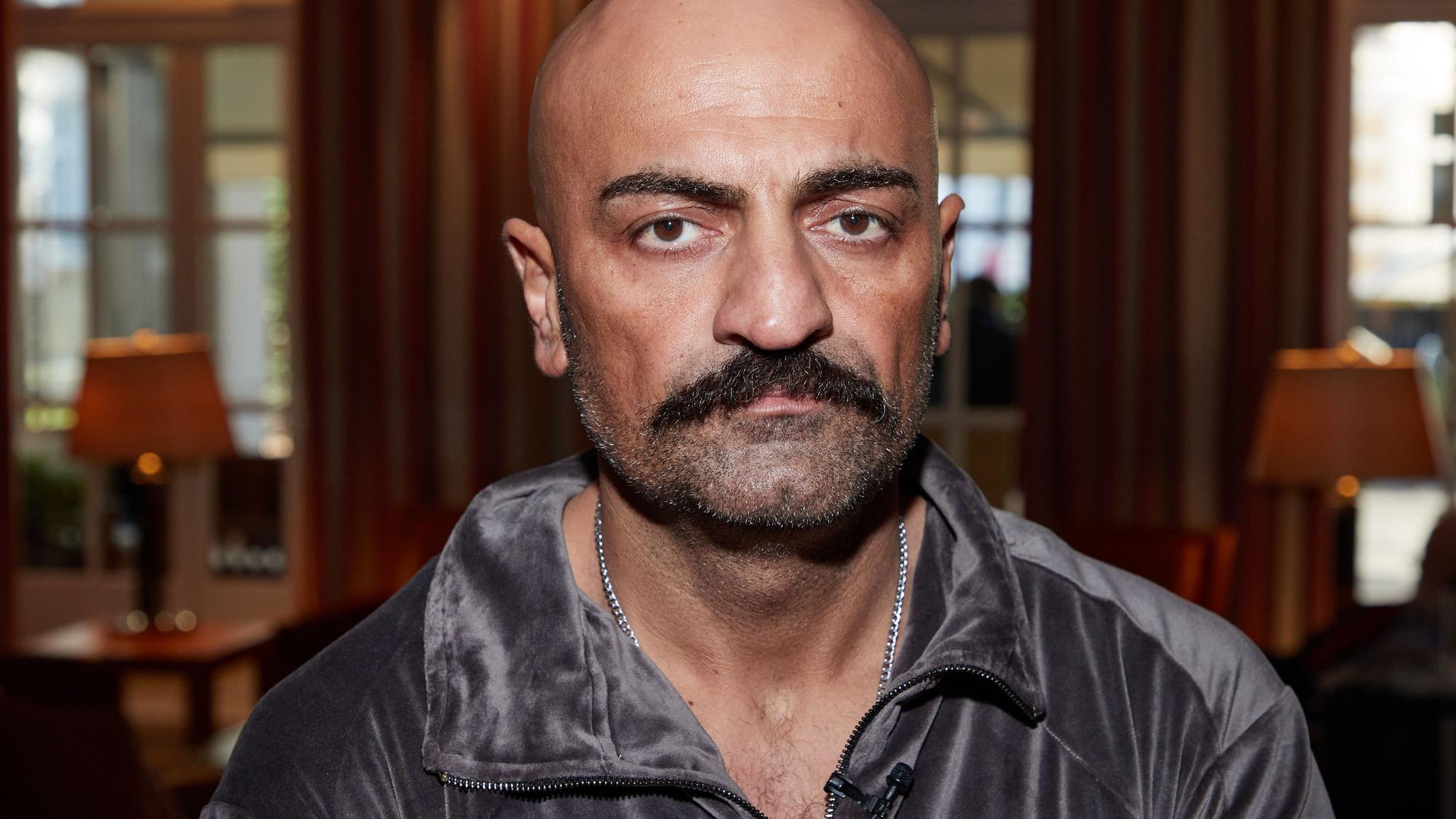 Das Bild zeigt Giwar Hajabi alias Xatar, im Foyer eines Hotels.