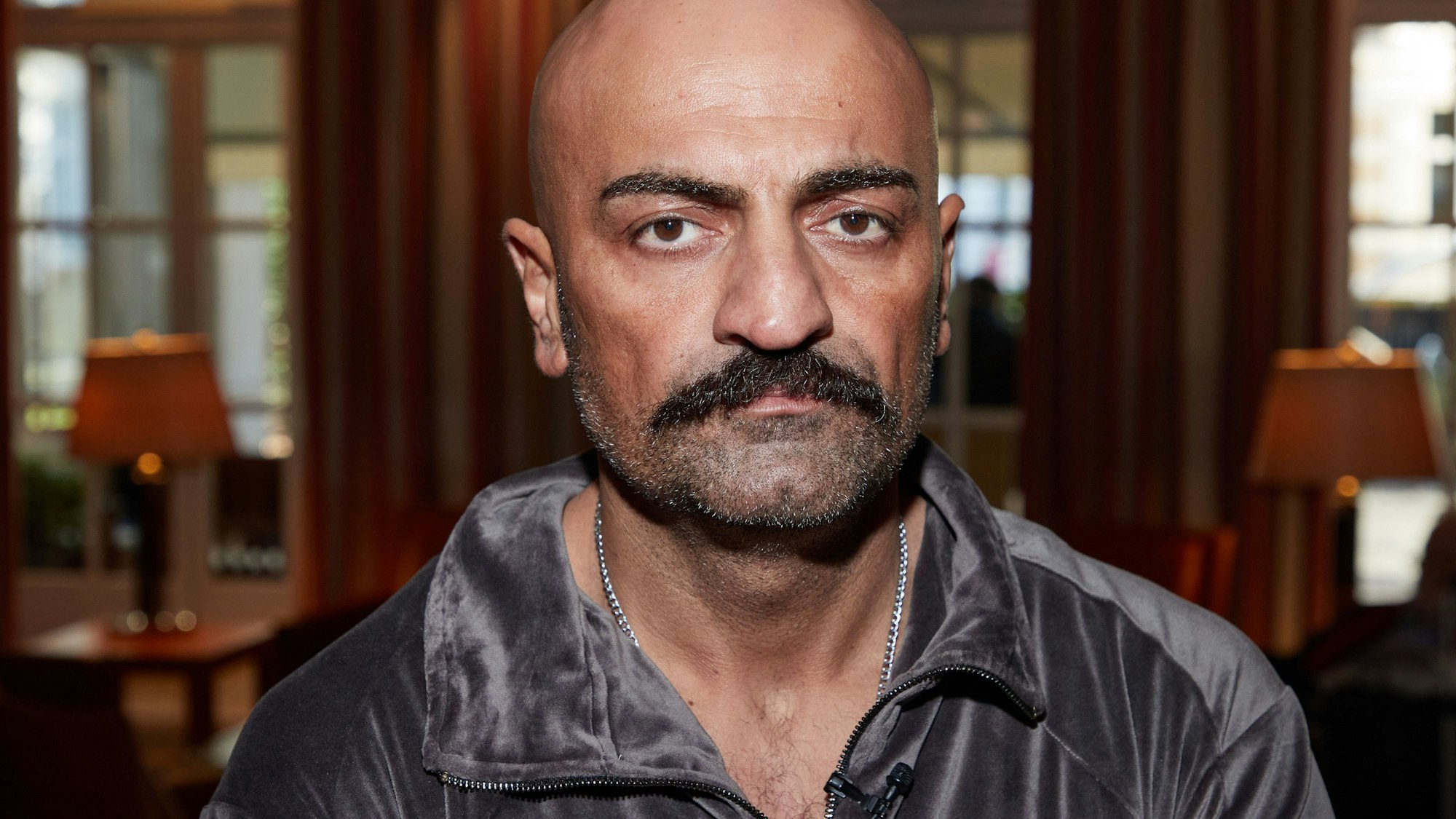 Das Bild zeigt Giwar Hajabi alias Xatar, im Foyer eines Hotels.