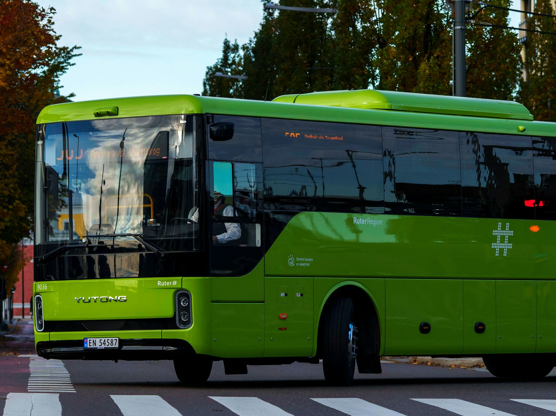 Ein grüner E-Bus des Herstellers Yutong fährt eine Kurve.