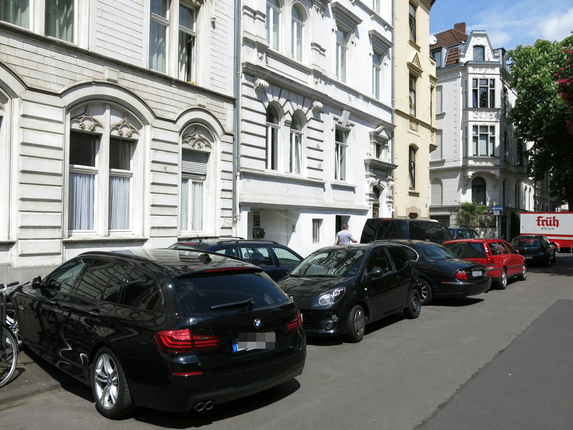 Autos parken kreuz und quer an einem Straßenrand.