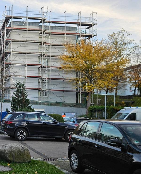 Ein Polizeifahrzeug steht auf einem Parkplatz in der Nähe eines Wohnhauses, in dem die Leichen einer Frau und zweier Kinder entdeckt worden waren.