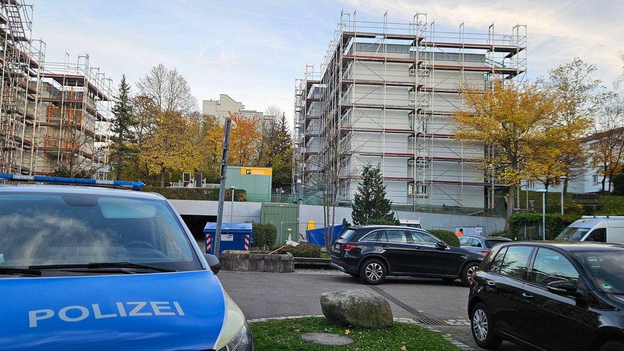 Ein Polizeifahrzeug steht auf einem Parkplatz in der Nähe eines Wohnhauses, in dem die Leichen einer Frau und zweier Kinder entdeckt worden waren.