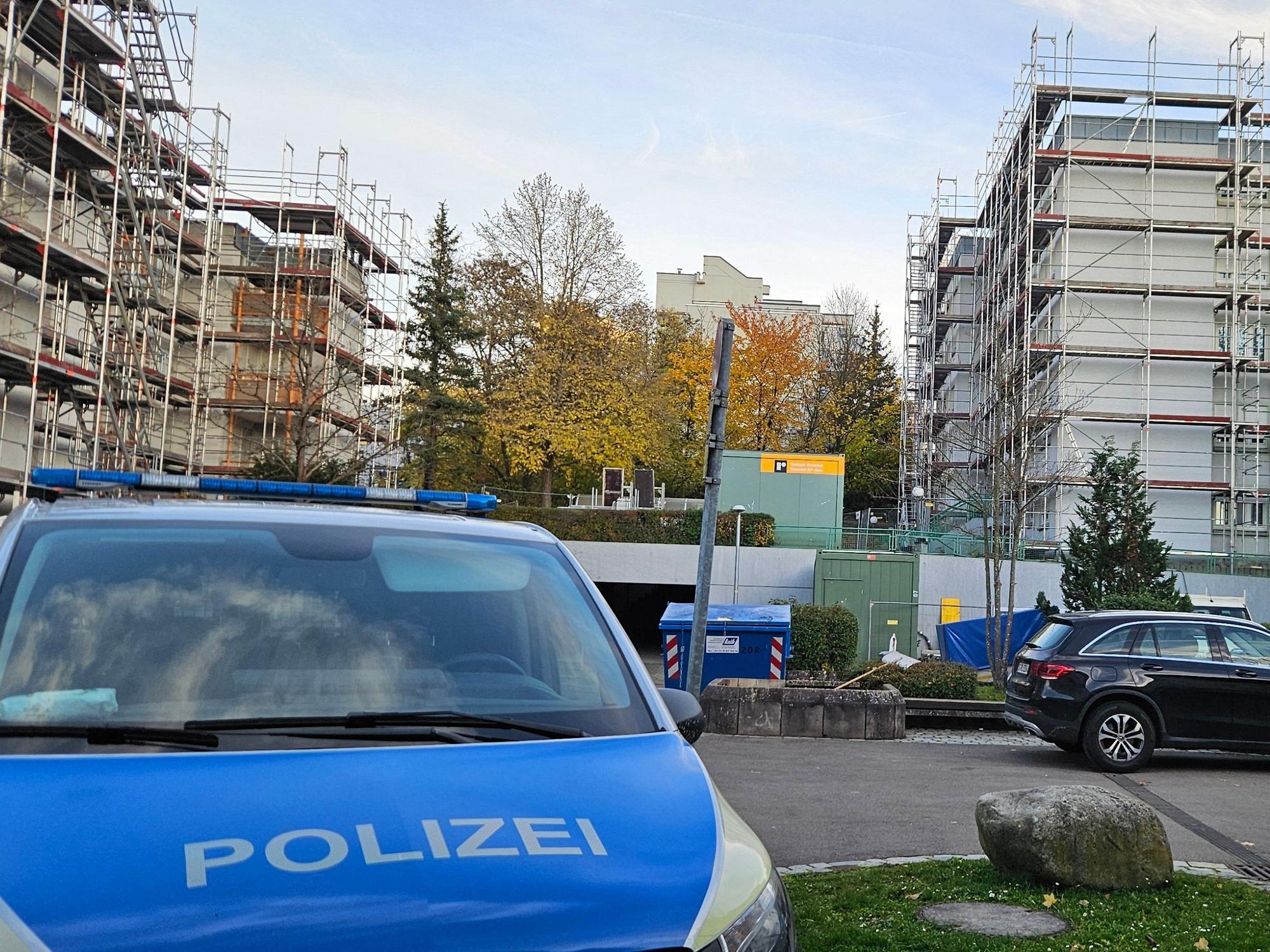 Ein Polizeifahrzeug steht auf einem Parkplatz in der Nähe eines Wohnhauses, in dem die Leichen einer Frau und zweier Kinder entdeckt worden waren.