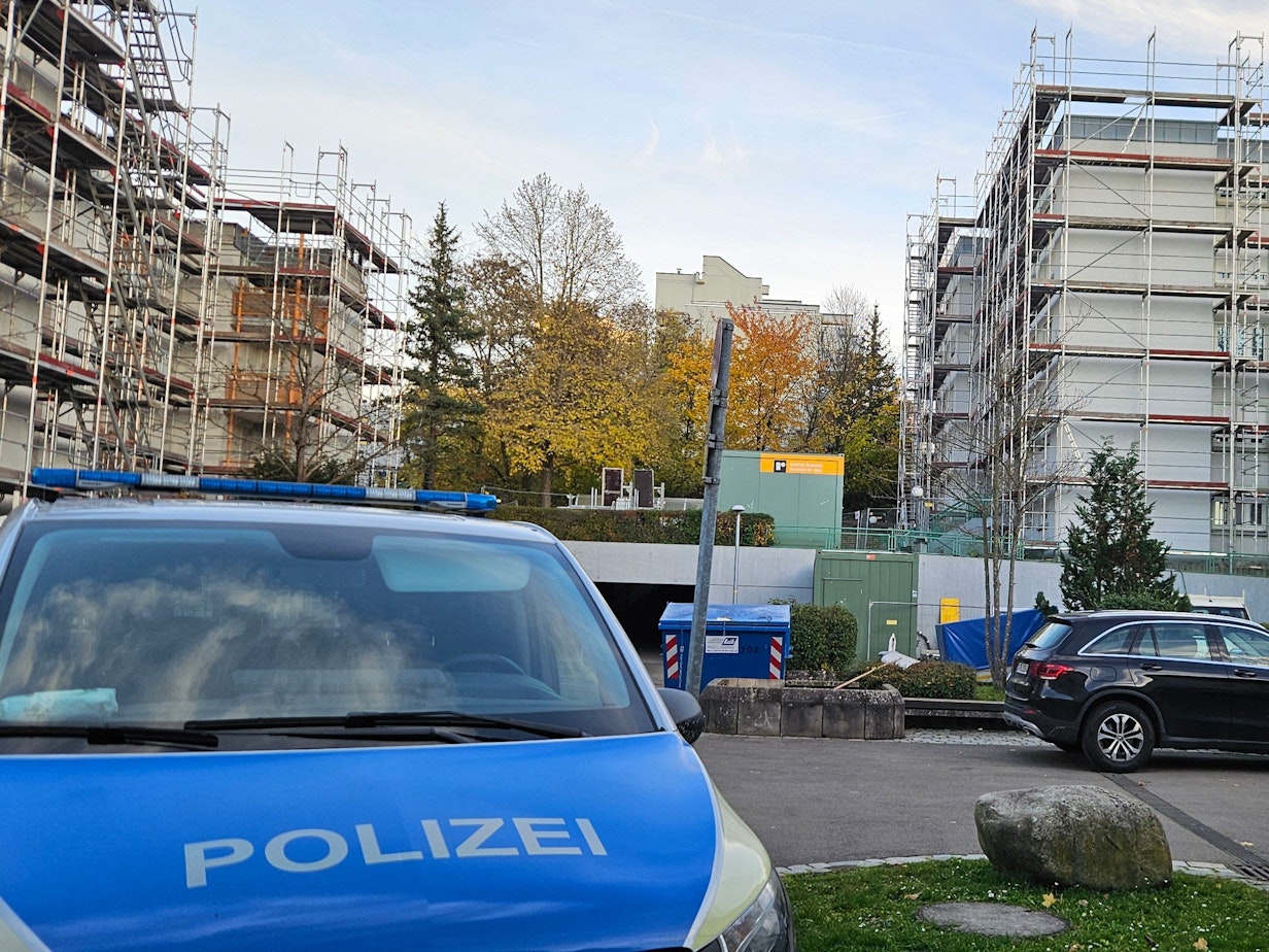 Ein Polizeifahrzeug steht auf einem Parkplatz in der Nähe eines Wohnhauses, in dem die Leichen einer Frau und zweier Kinder entdeckt worden waren.